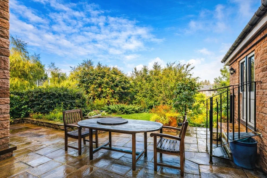 A patio with a table and chairs in the garden