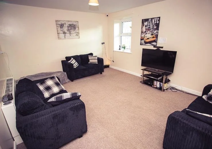 A spacious lounge with sofas and a television