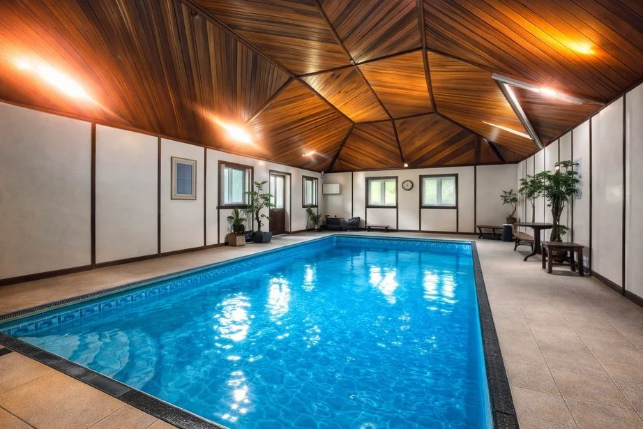 An indoor swimming pool with a wooden ceiling
