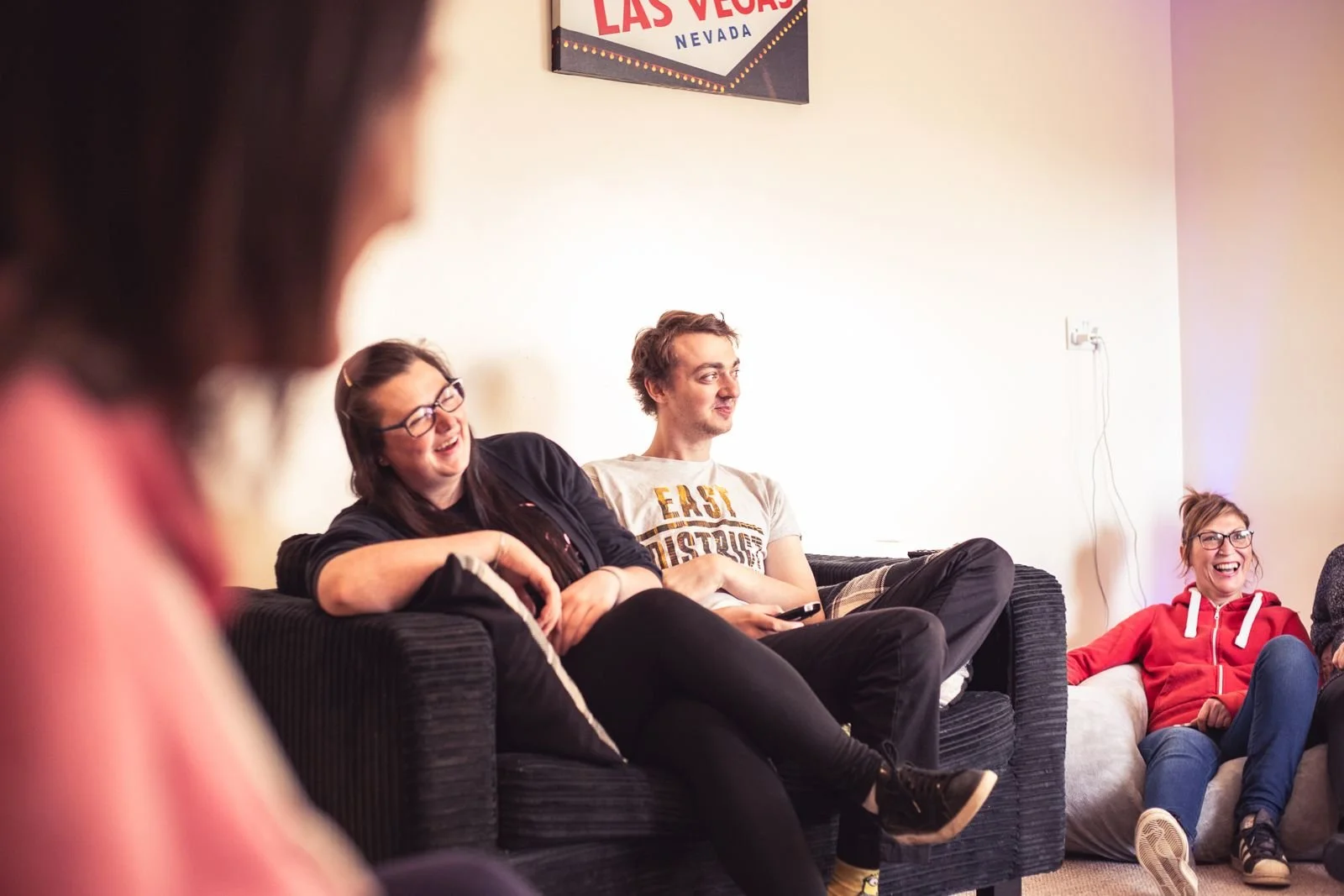 A group laughing together on sofas in a shared lounge