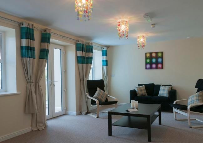A lounge with sofas, a coffee table and French doors
