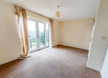 A carpeted lounge with French doors