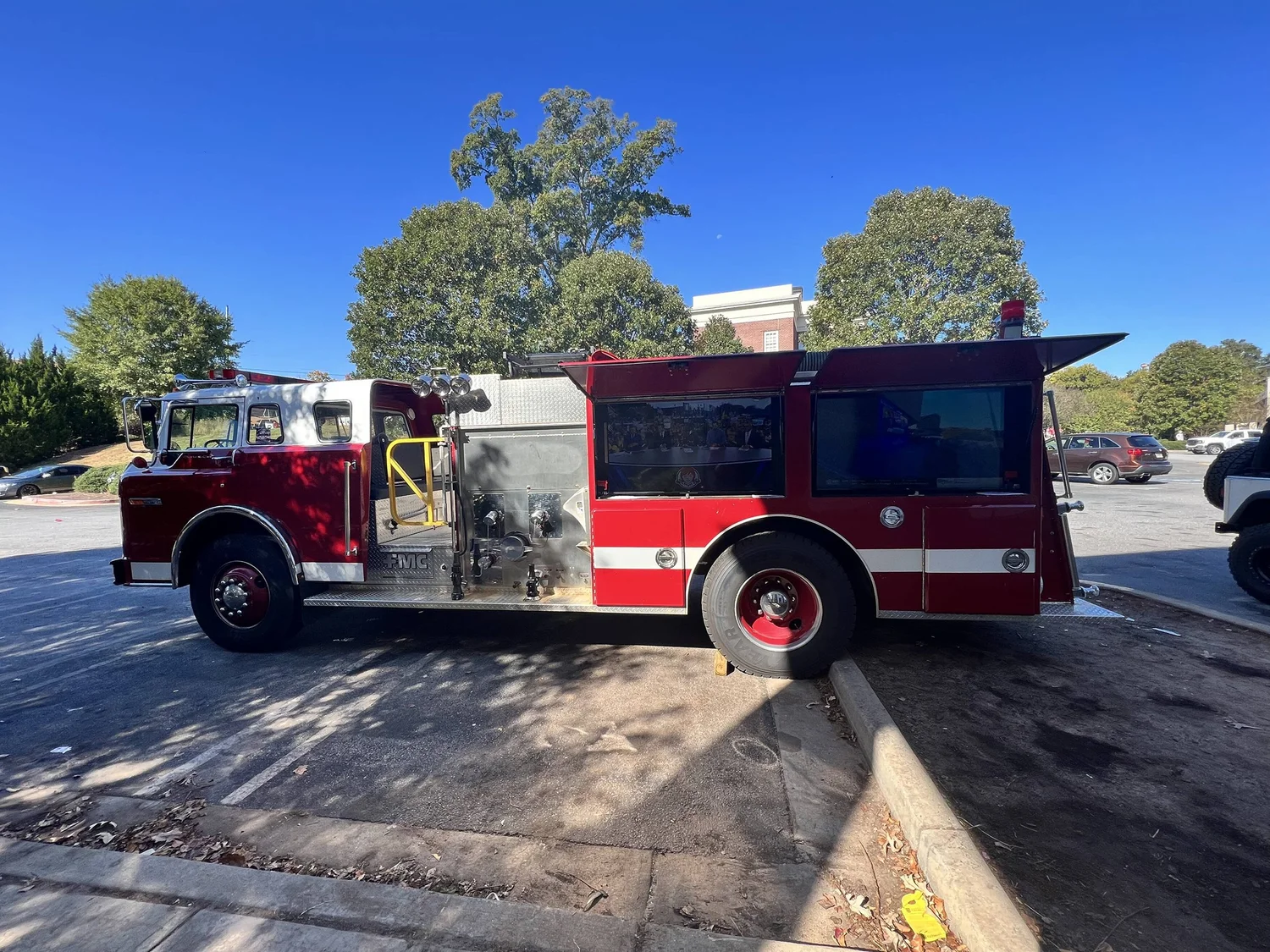 Red-and-white Fire Engine Events truck with two side-mounted screens set up outdoors.