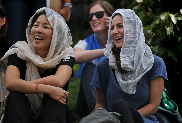 Christine Koh and Liz laughing and generally enjoying life (in their FashionABLE scarves , natch !). (Speaking of which! Last night, the ONEMoms heard from the founder of FashionABLE, Barrett Ward, who said that as a result of all the scarves that were bought from people who read the ONEMoms posts this past month, FashionABLE is able to hire three more women -- that's three more women off the street, who no longer have to turn to a life of prostitution to feed themselves and their children! You did that! You should be seriously, seriously proud. These scarves are magic , I tell you.)