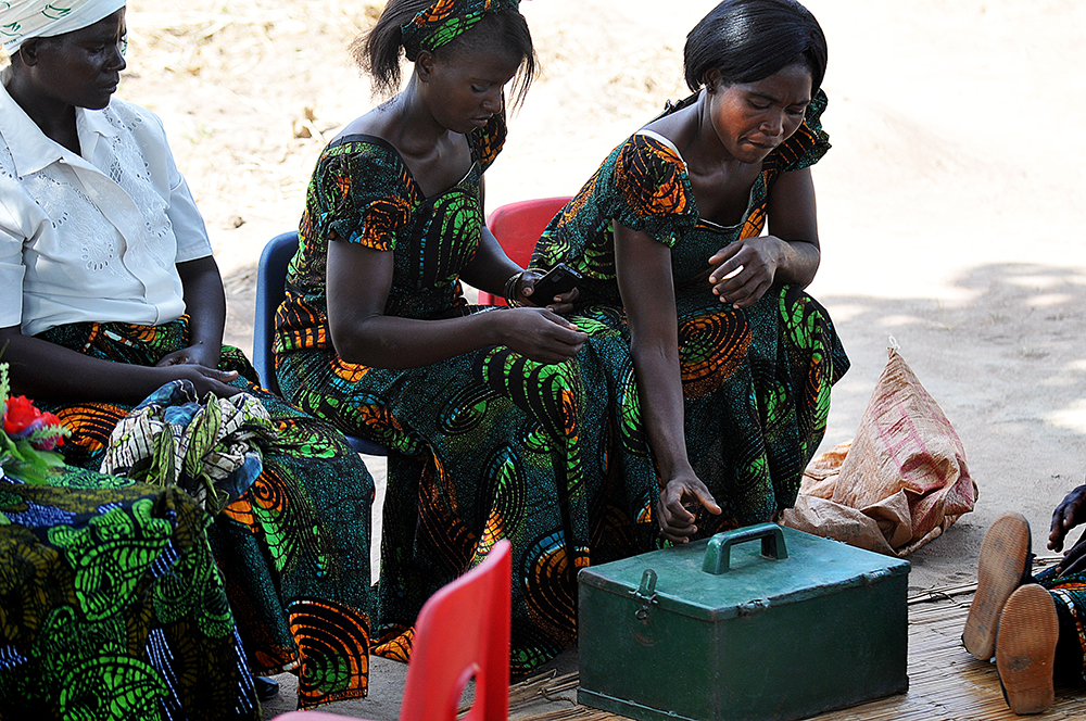 The meeting of these women's savings and loan association is about to begin. &nbsp;Their money is kept in a metal cashbox, with three different locks -- and three different women are the keepers of the keys.