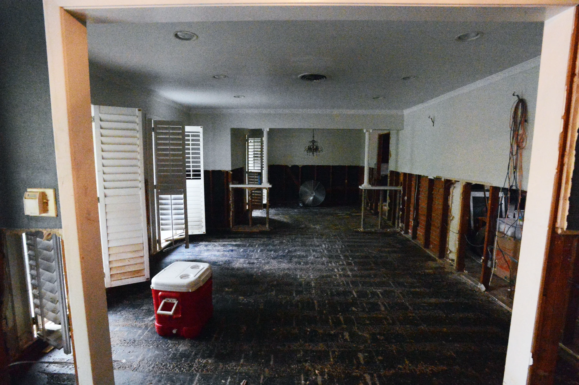 Our living/dining room, with drywall and flooring removed, and fans going to help dry everything else out, to mitigate mold growth. ( This is what these rooms looked like 5 months ago .)