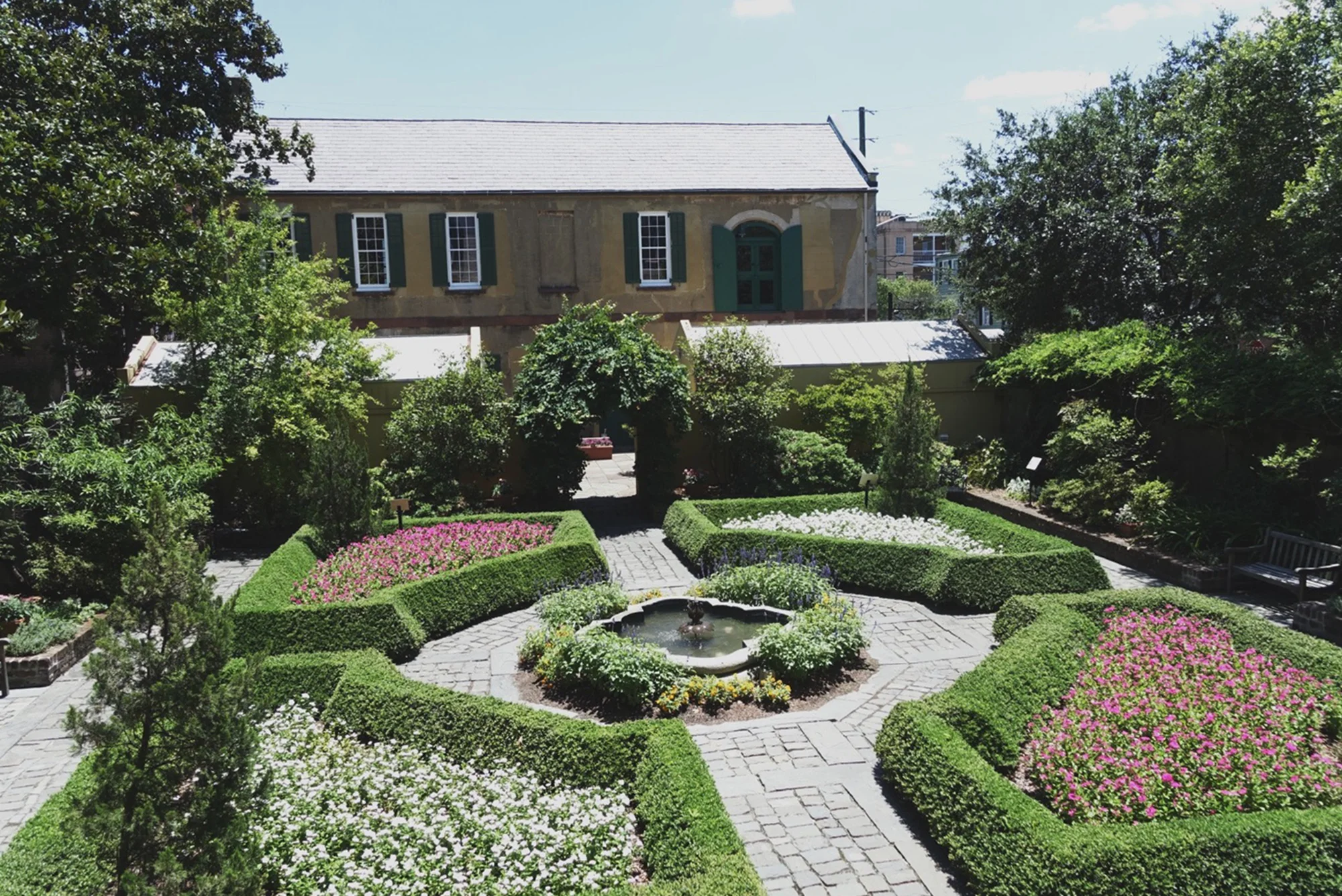 The view from the main house back toward the slave quarters. The gardens aren’t original to the house — they were added in the 1950s. Back during the time when the house was occupied by the slaveowners, this would’ve just been an empty dirt lot, with a well where the ivy-covered archway is, and a privy/outhouse somewhere for the enslaved people’s use.