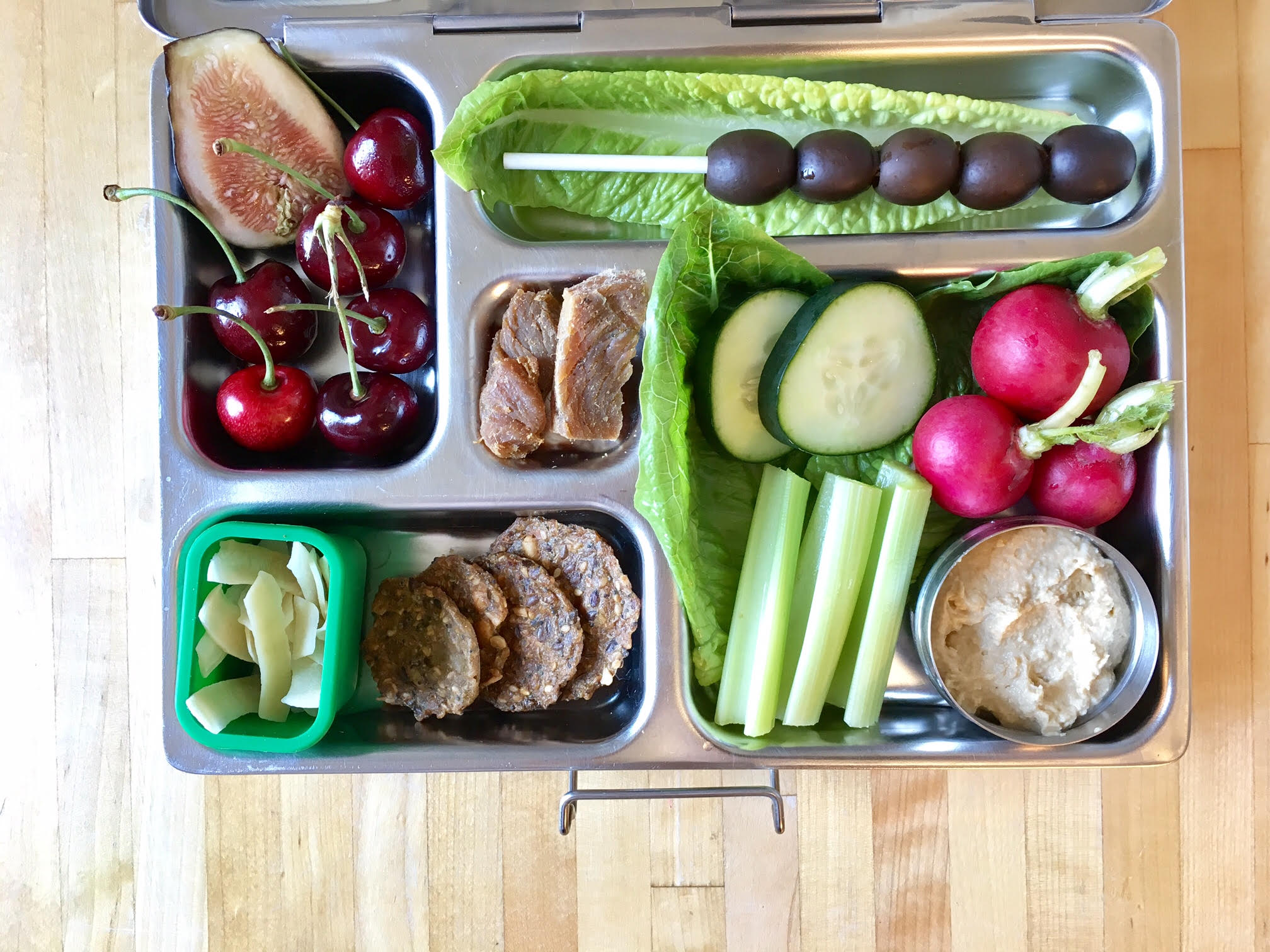 hummus with celery, cukes and radishes, black olives, turkey jerky, crackers, coconut chips, cherries and fig