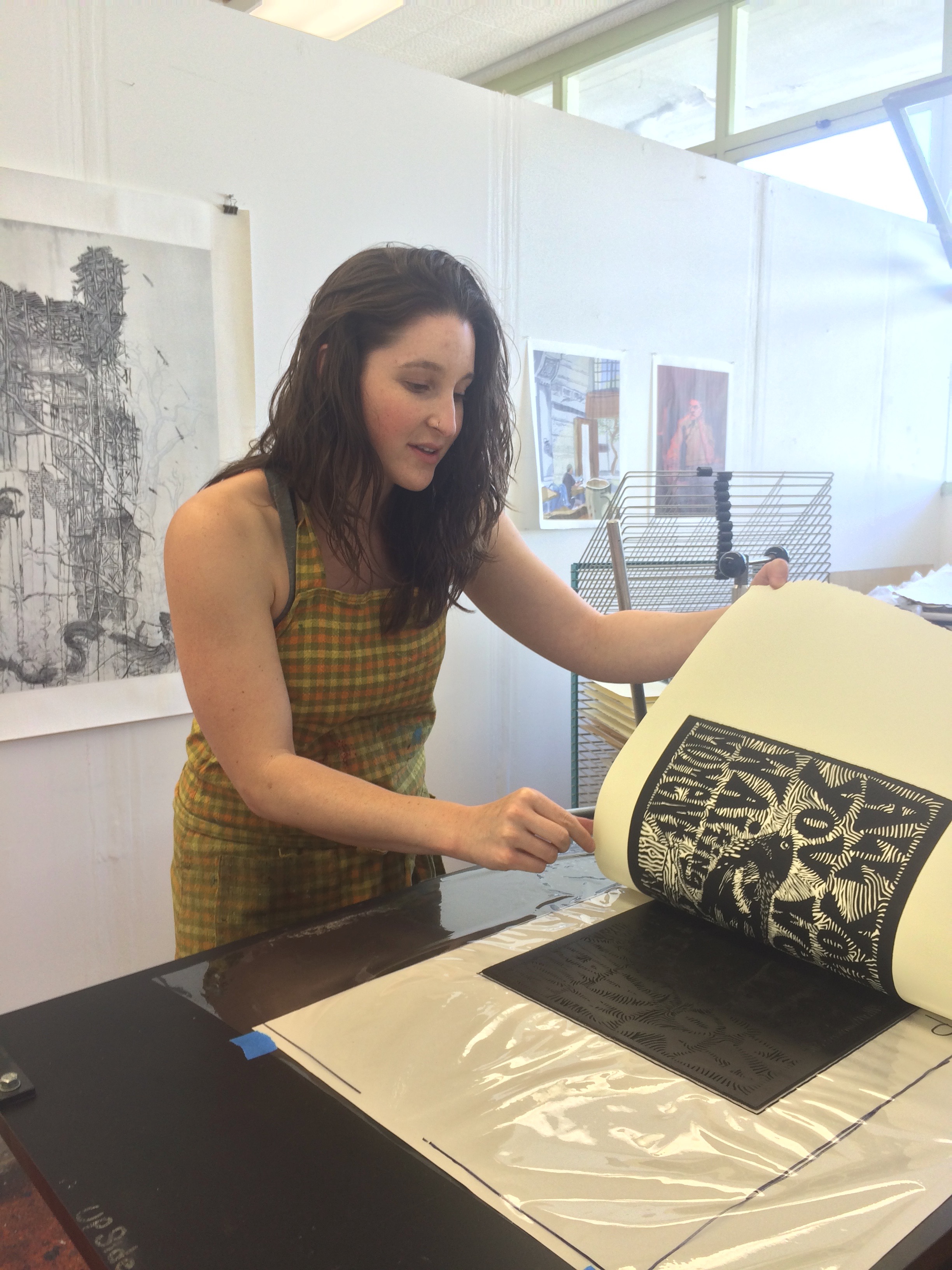 Naomi Branz (Santa Cruz Artist) prints her linoleum block on the etching press.