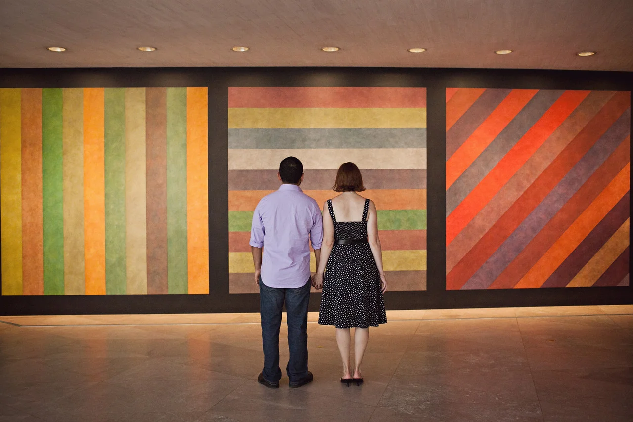 Engaged couple standing in front of artwork at the National Gallery of Art in Washington, DC - Maria Vicencio Photography Engagement Session
