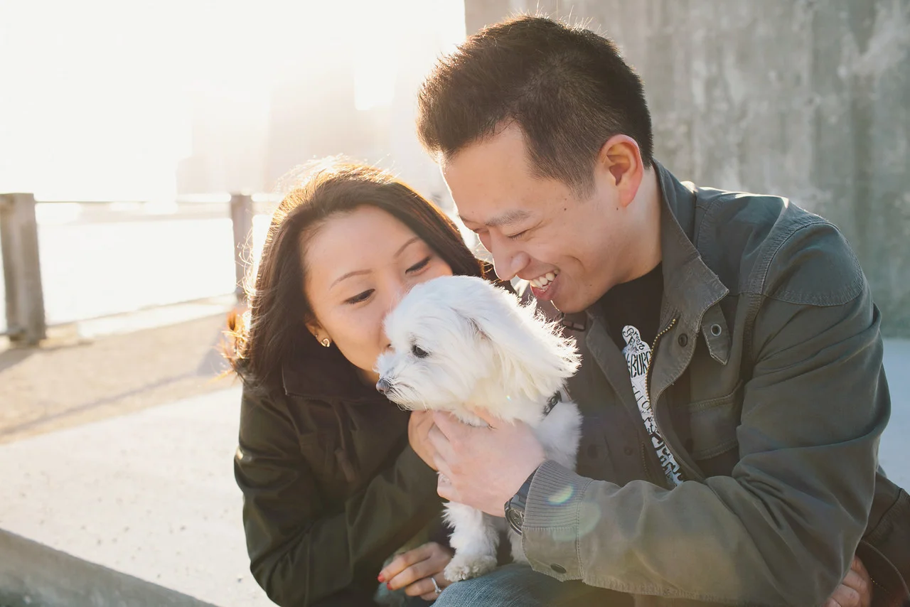 Engaged couple kissing their dog at Brooklyn Bridge Park in NYC - Maria Vicencio Photography Engagement Session