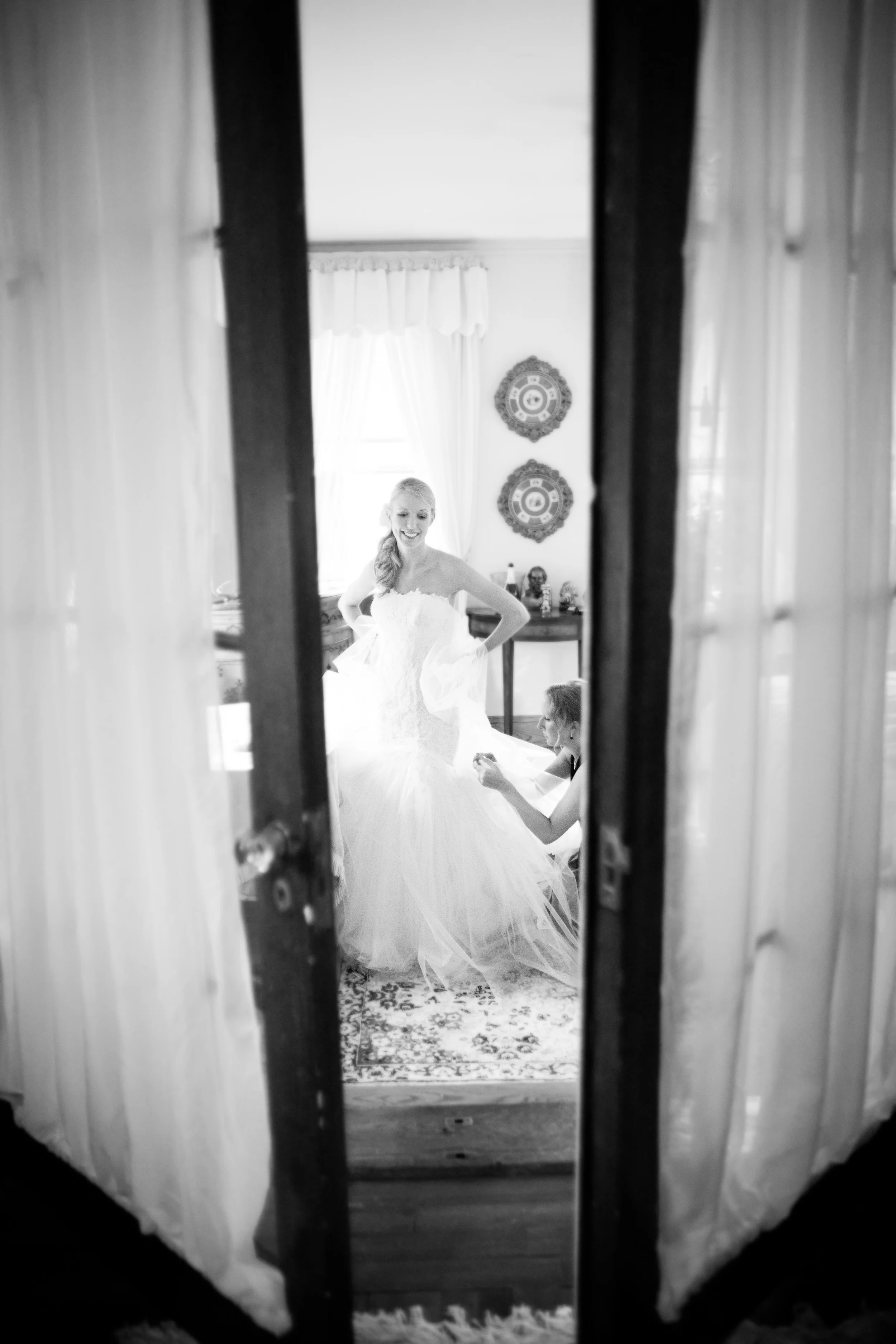 Black and white shot of bride being bustled at Gramercy Mansion - Maria Vicencio Photography Weddings