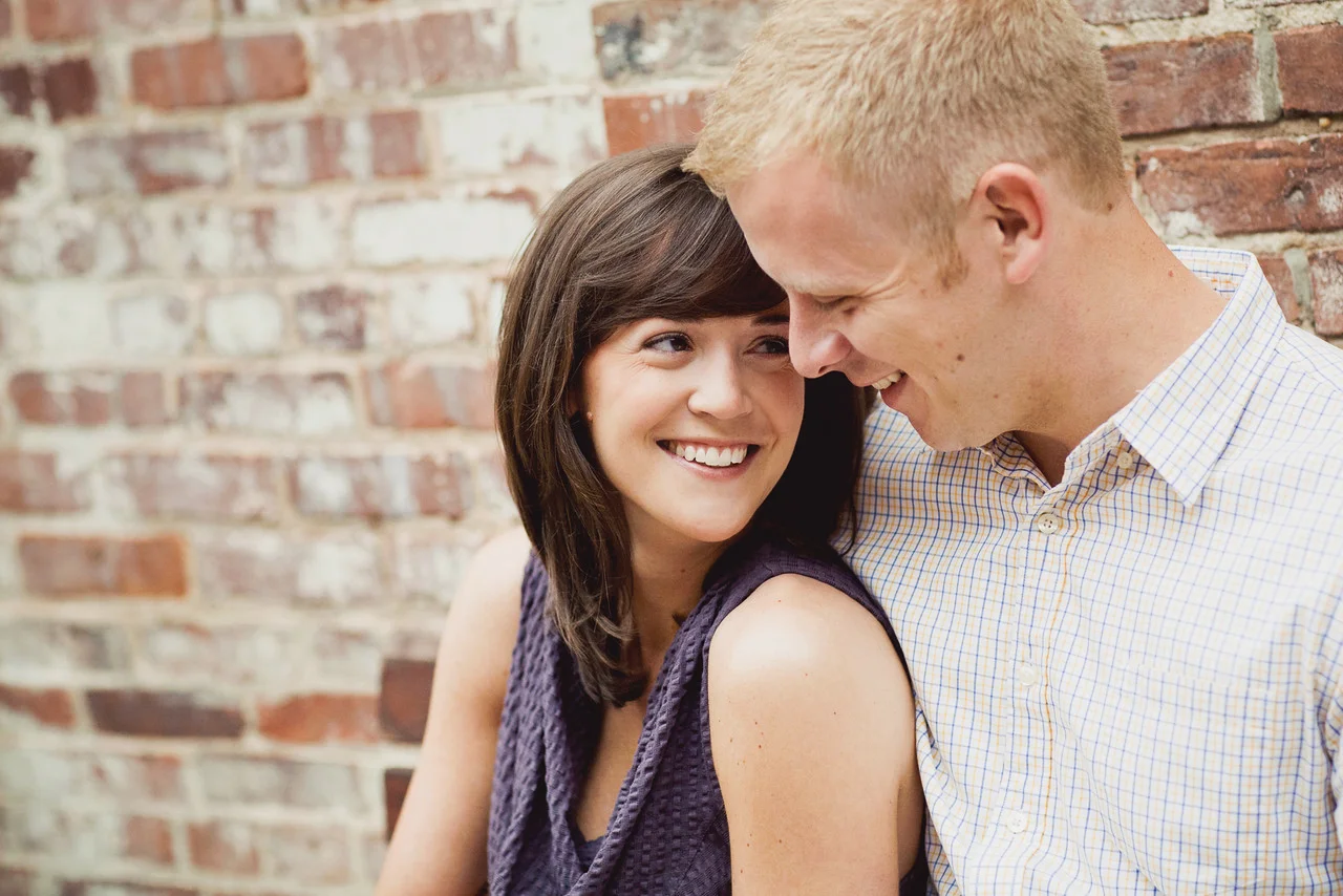 Engaged couple against brick wall - Maria Vicencio Photography Engagement Session