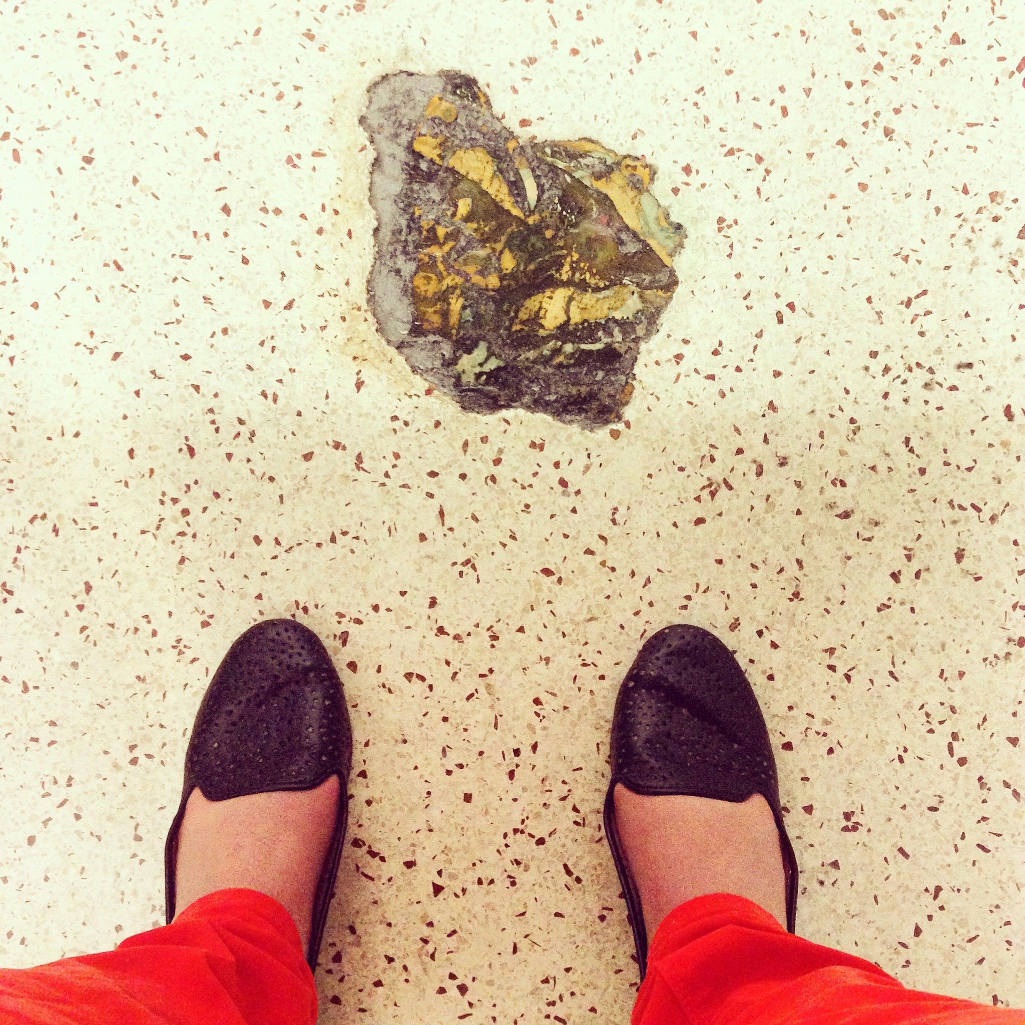 This is embedded floor art that looks like poop in a Denver International Airport bathroom.