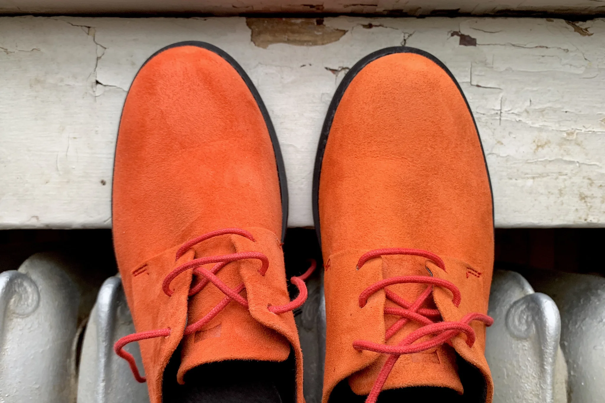 a pair of orange suede campers with red laces