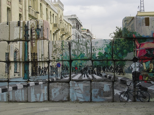 Graffiti on a cinderblock wall blocking an entrance to Tahrir Square