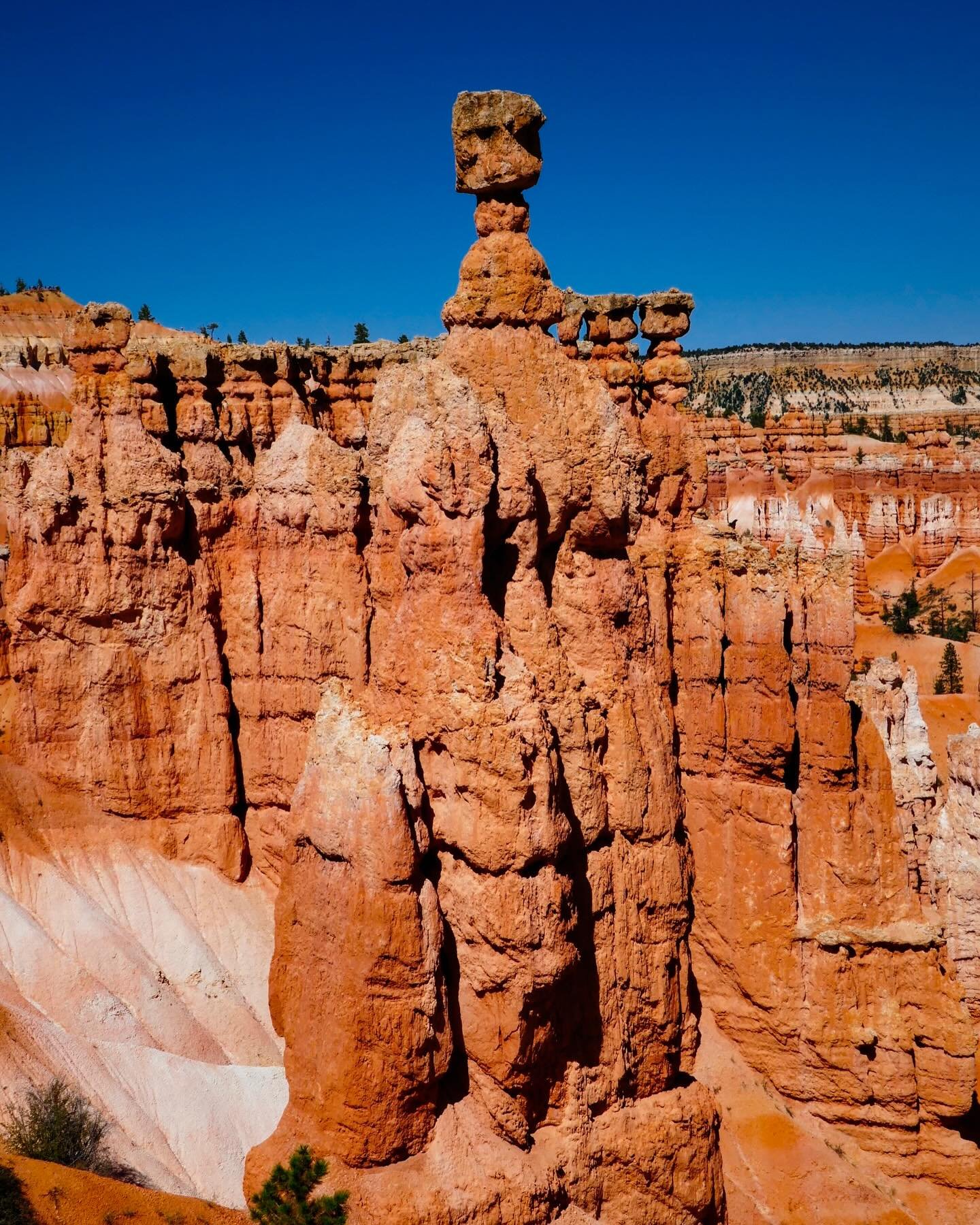&ldquo;Hoodoo&rdquo; &copy; 2025 Skip Hunt

A striking rock formation towers under a vibrant blue sky, showcasing a stunning display of natural architecture with its red and orange hues. The precarious balancing of the rock on top adds a dramatic ele