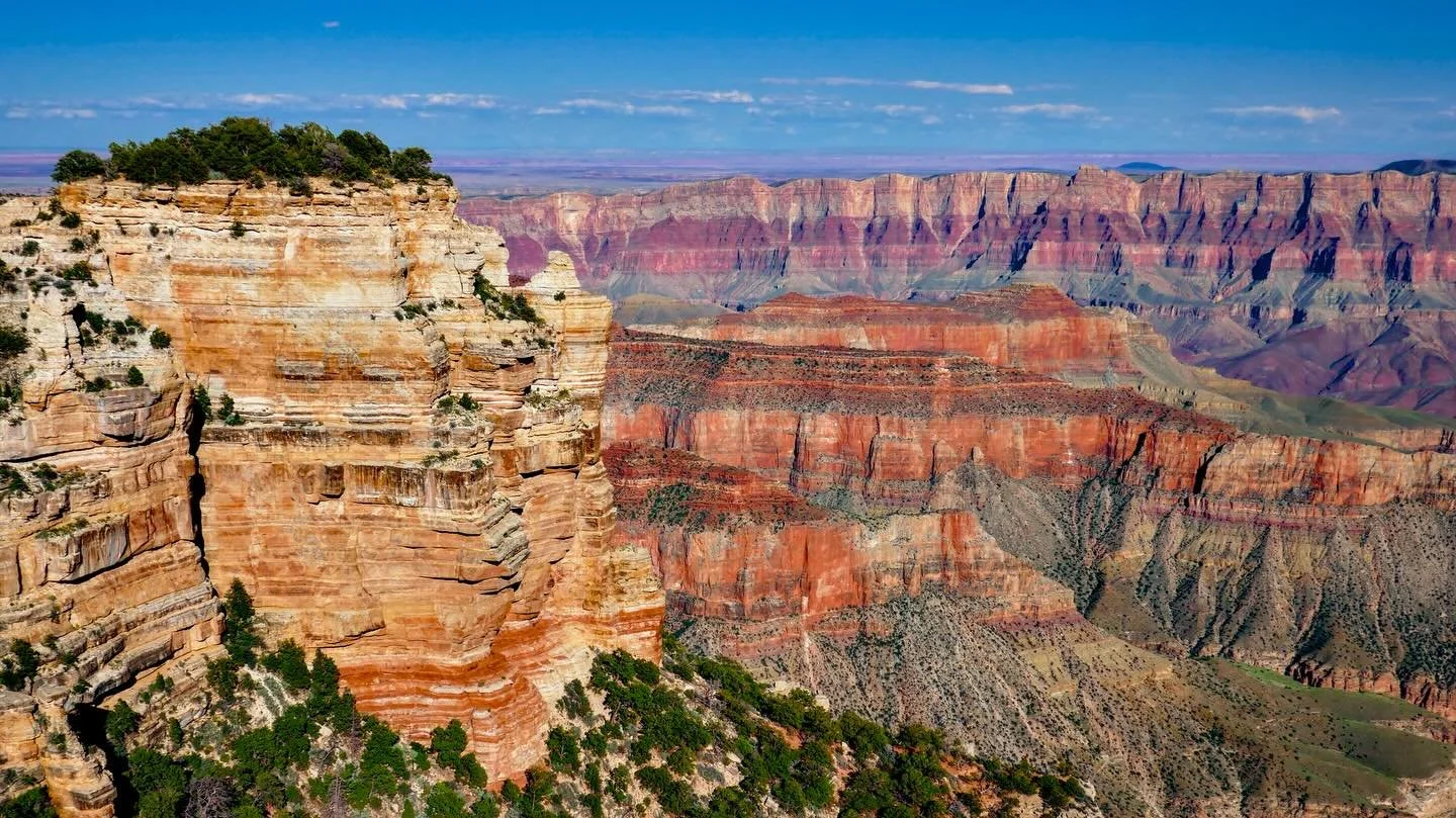&ldquo;The Greatest Cut&rdquo; &copy; 2025 Skip Hunt

A stunning view of the Grand Canyon showcases its vast and colorful landscape, with layered rock formations stretching out under a clear blue sky. Rich hues of red, orange, and brown dominate the 