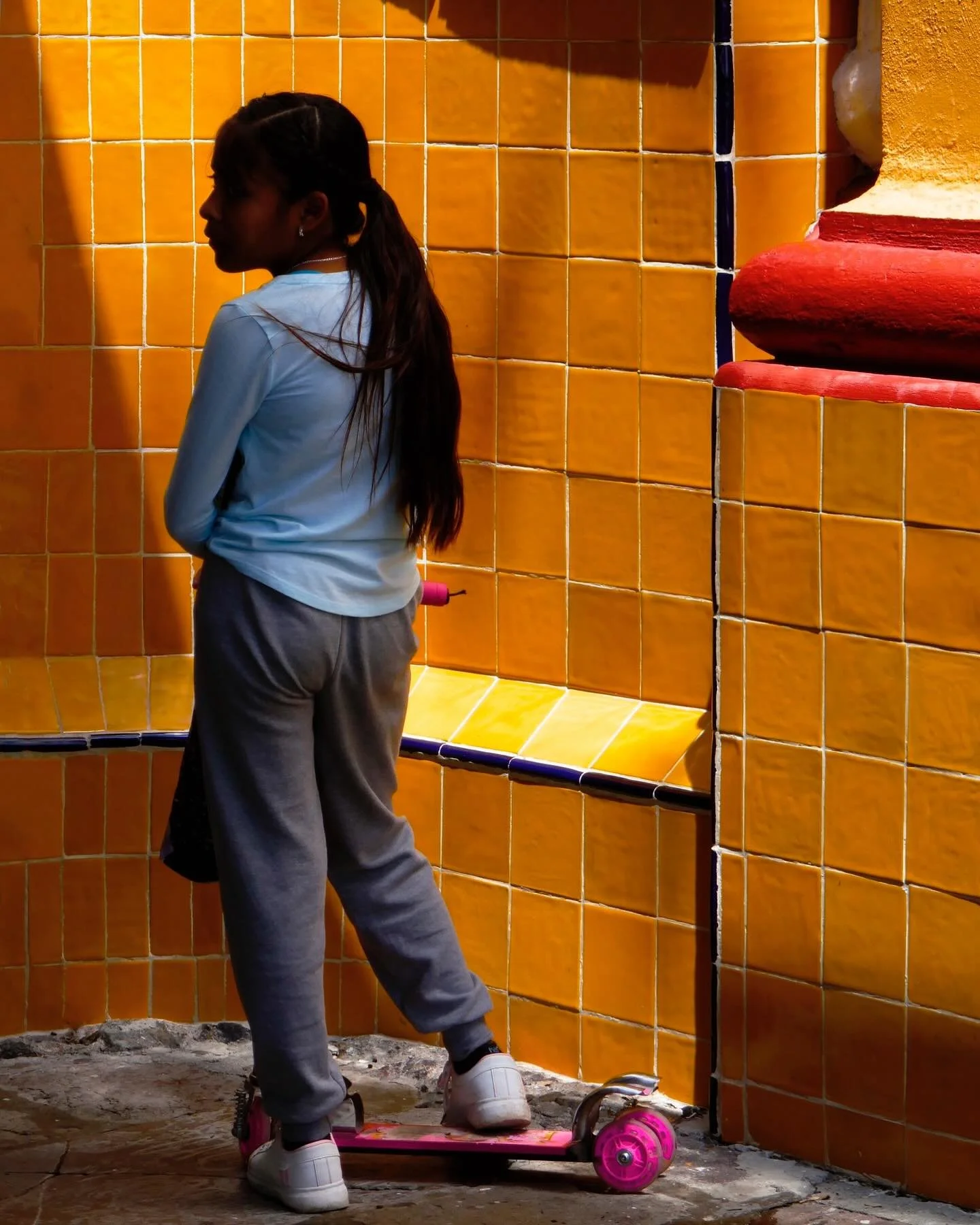 &ldquo;Scooter&rdquo; &copy; 2025 Skip Hunt

A young girl stands with a scooter against a backdrop of vibrant orange and yellow tiles, bathed in warm sunlight. The bright colors and architectural details create a lively atmosphere.

Cholula, Mexico