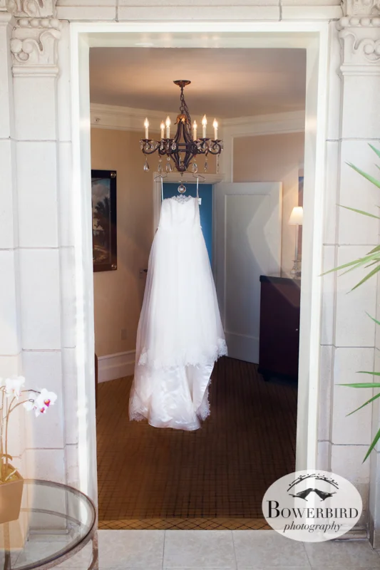 T he bride's wedding dress, called "High Society," hangs on a chandelier. © Bowerbird Photography 2013; Mark Hopkins Hotel, San Francisco.