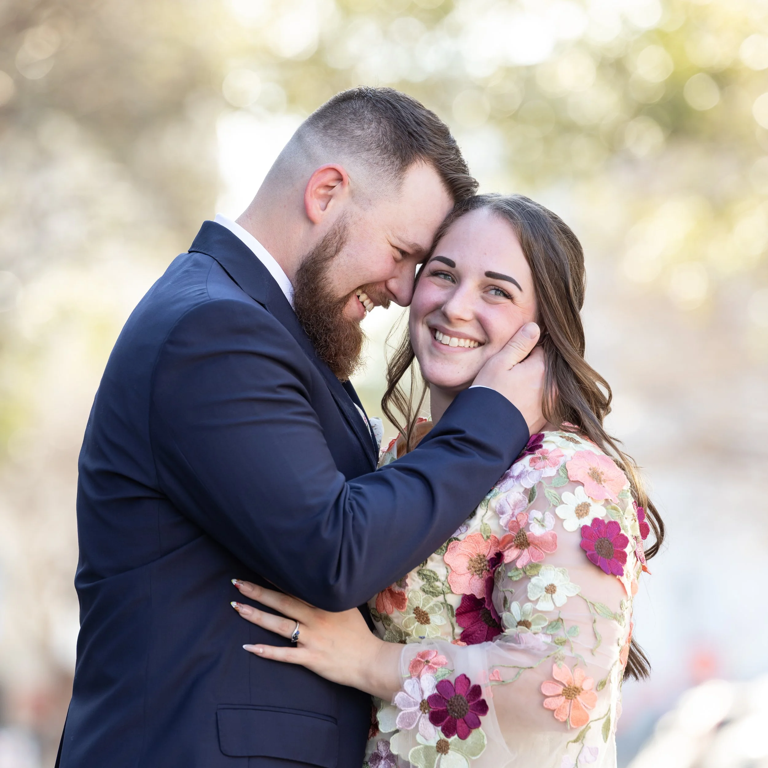 eloping couple embrace bride in floral overlay dress
