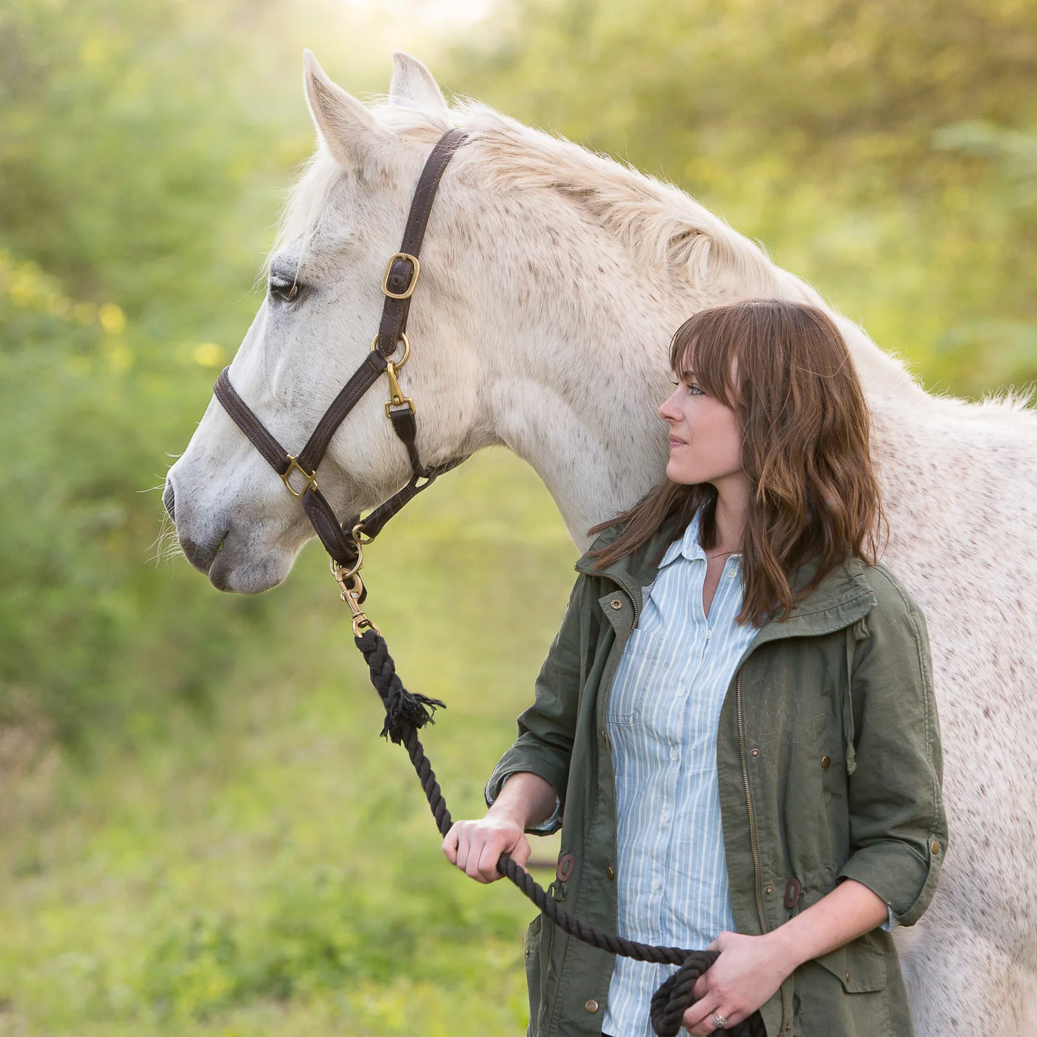 casual portrait of woman and grey mare natural light