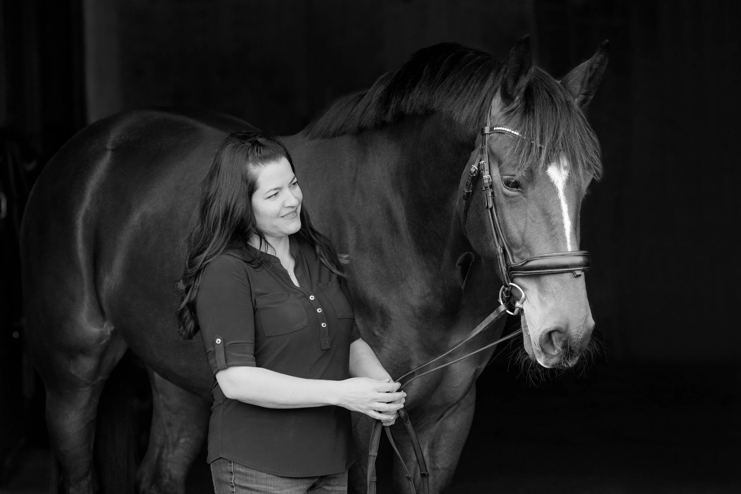 woman and her bay mare with dark background
