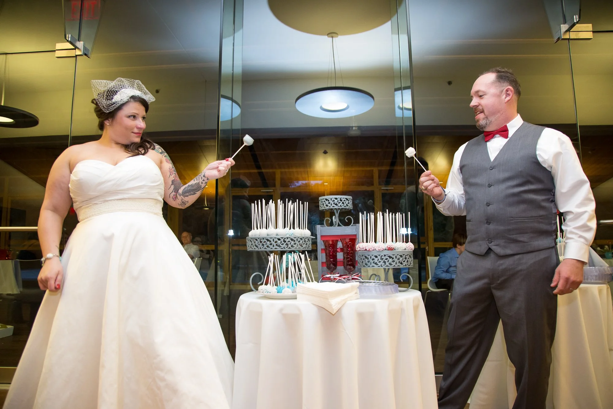 bride and groom with cake pops instead of cutting cake