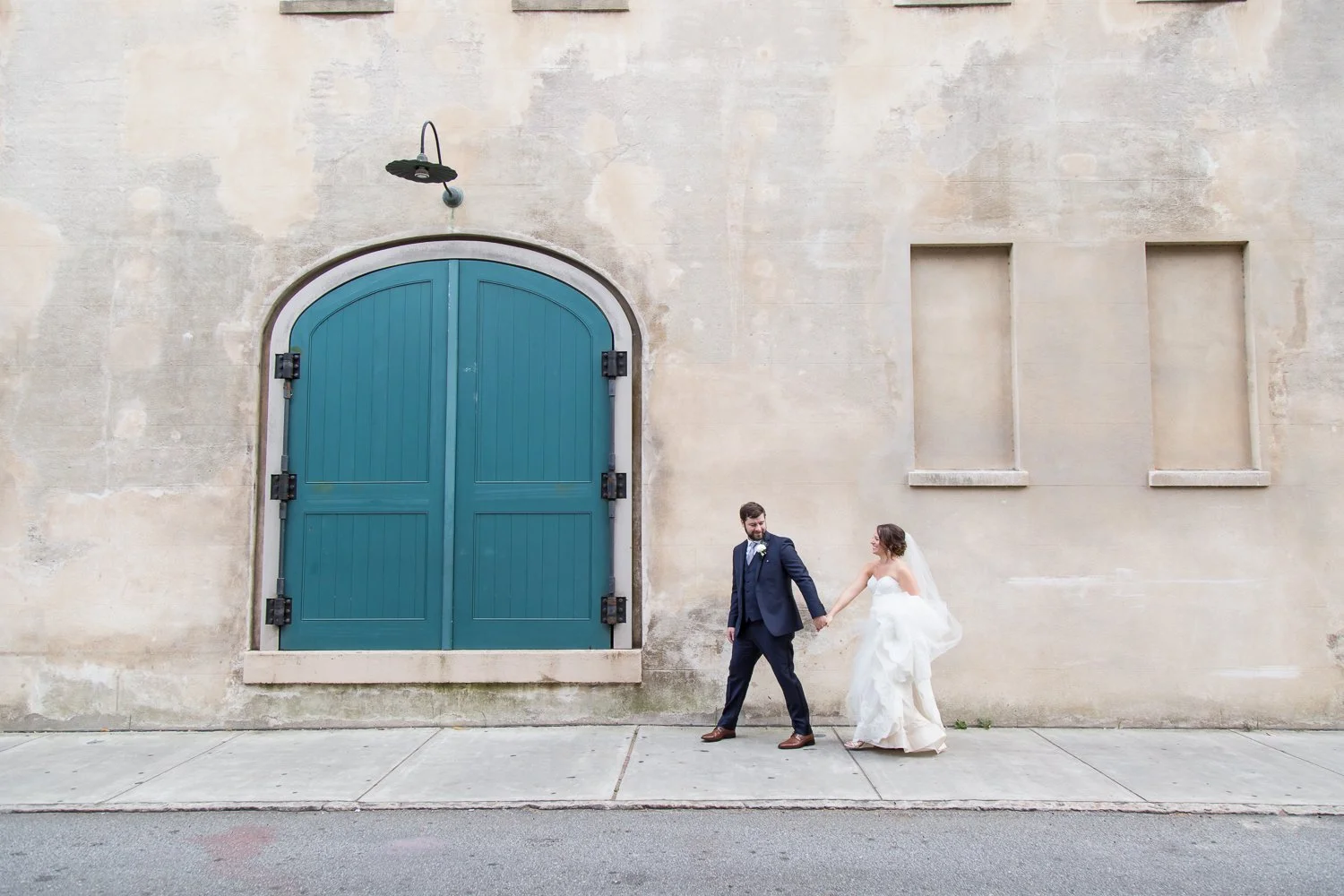 bride and groom walking streets of Charleston near Dock Street Theater