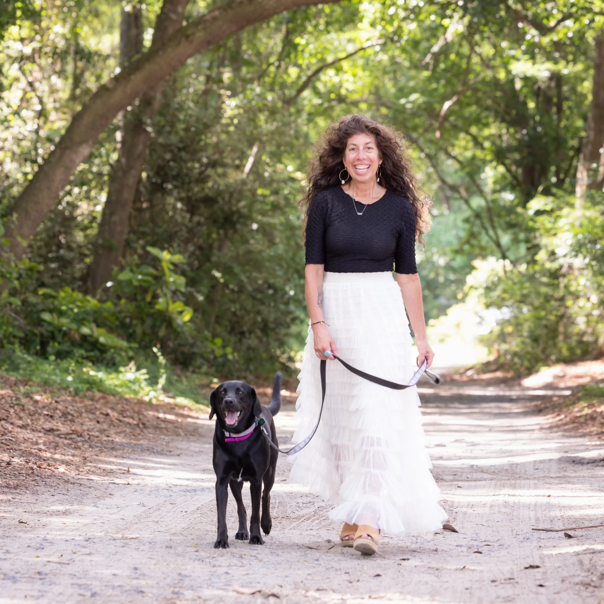 woman and black dog walking