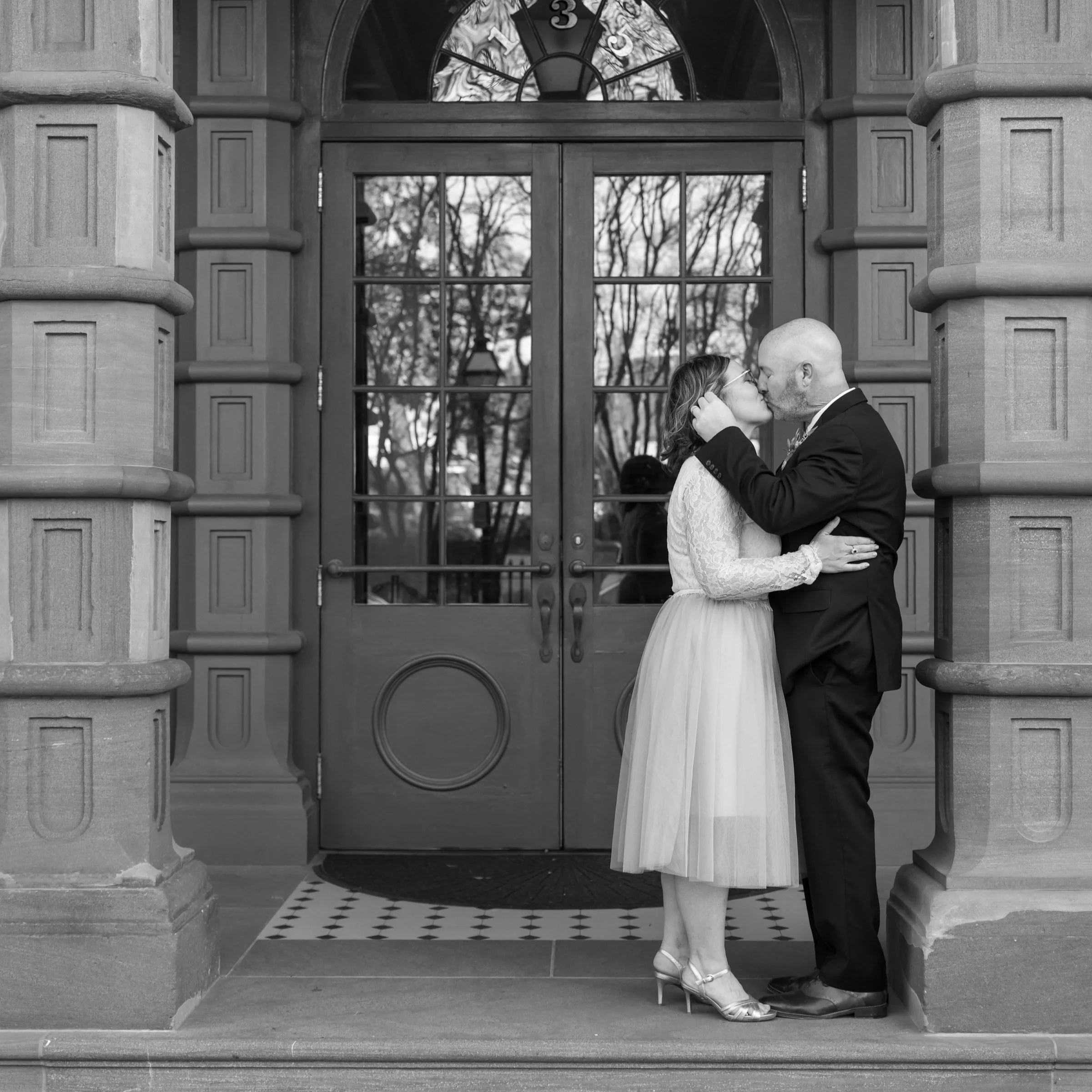 eloping couple kissing in a theater doorway