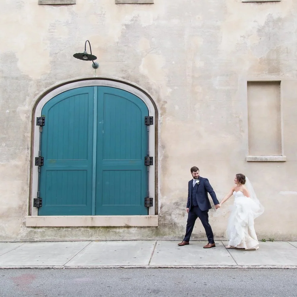 bride and groom holding hands walking on Charleston street