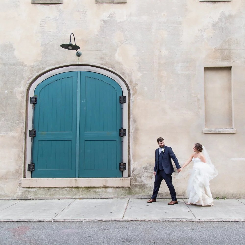 bride and groom holding hands walking on Charleston street