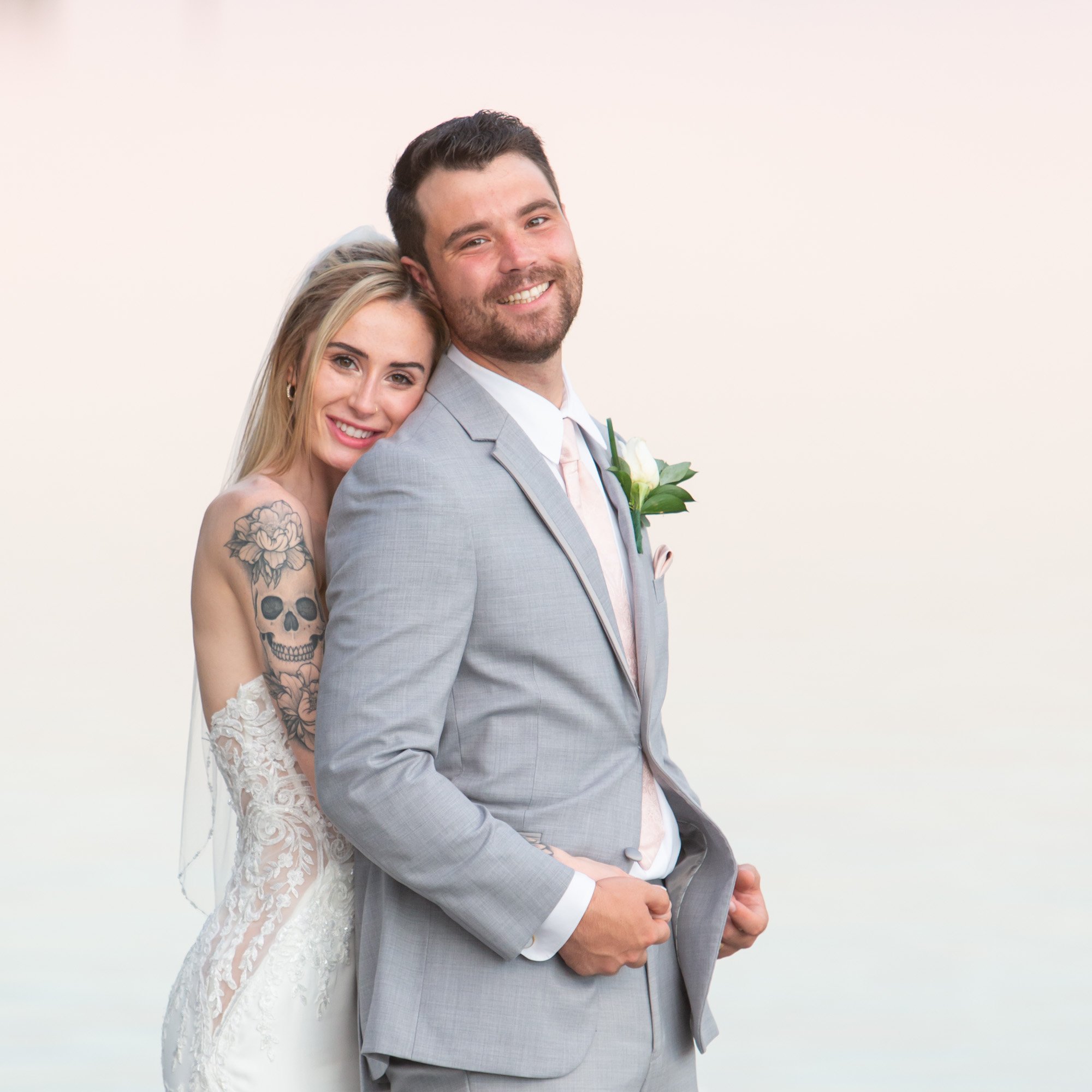 tattooed bride and groom with water background