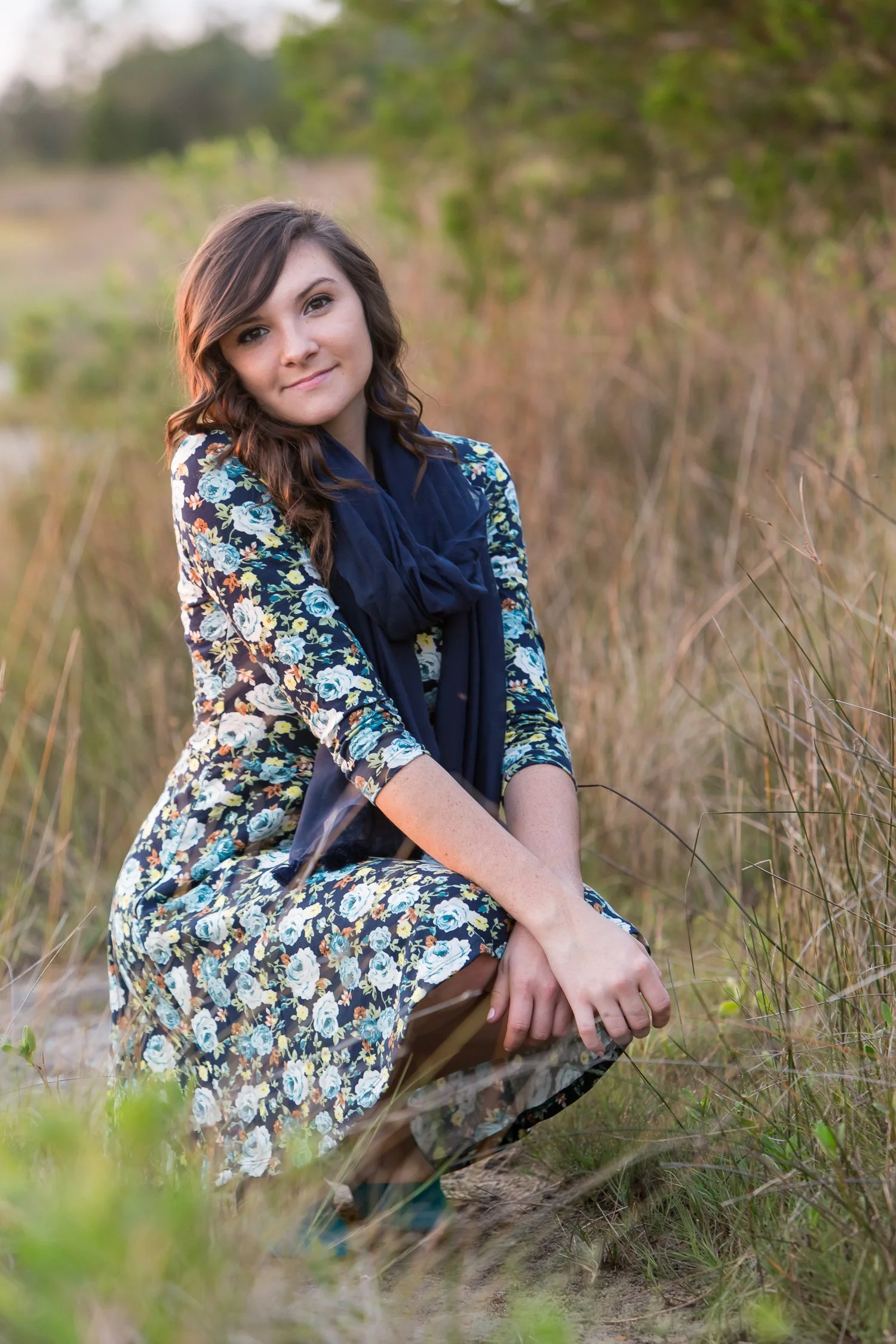 teen kneeling in the marsh grass outdoors