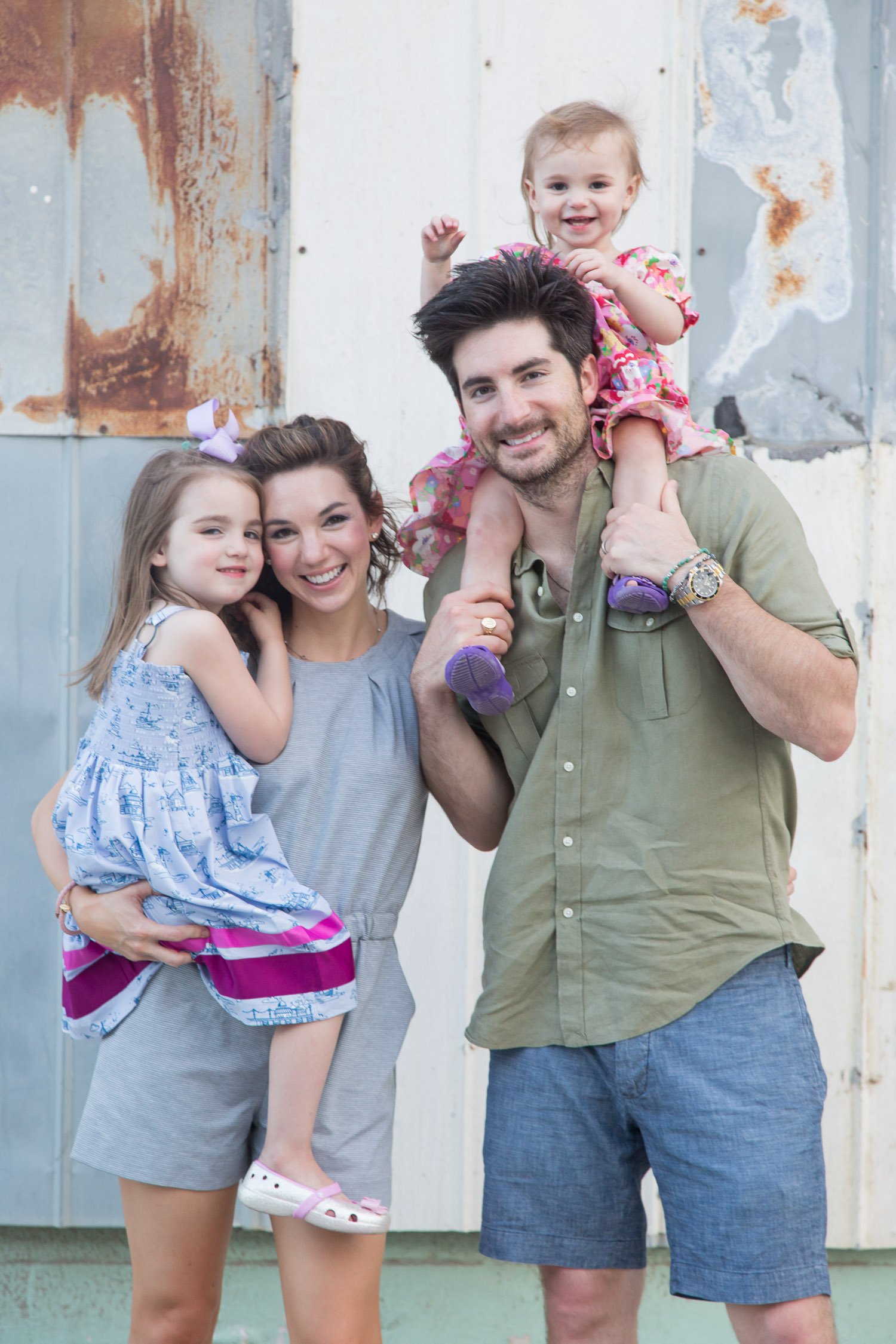 casual family portrait of girl parents with rustic background