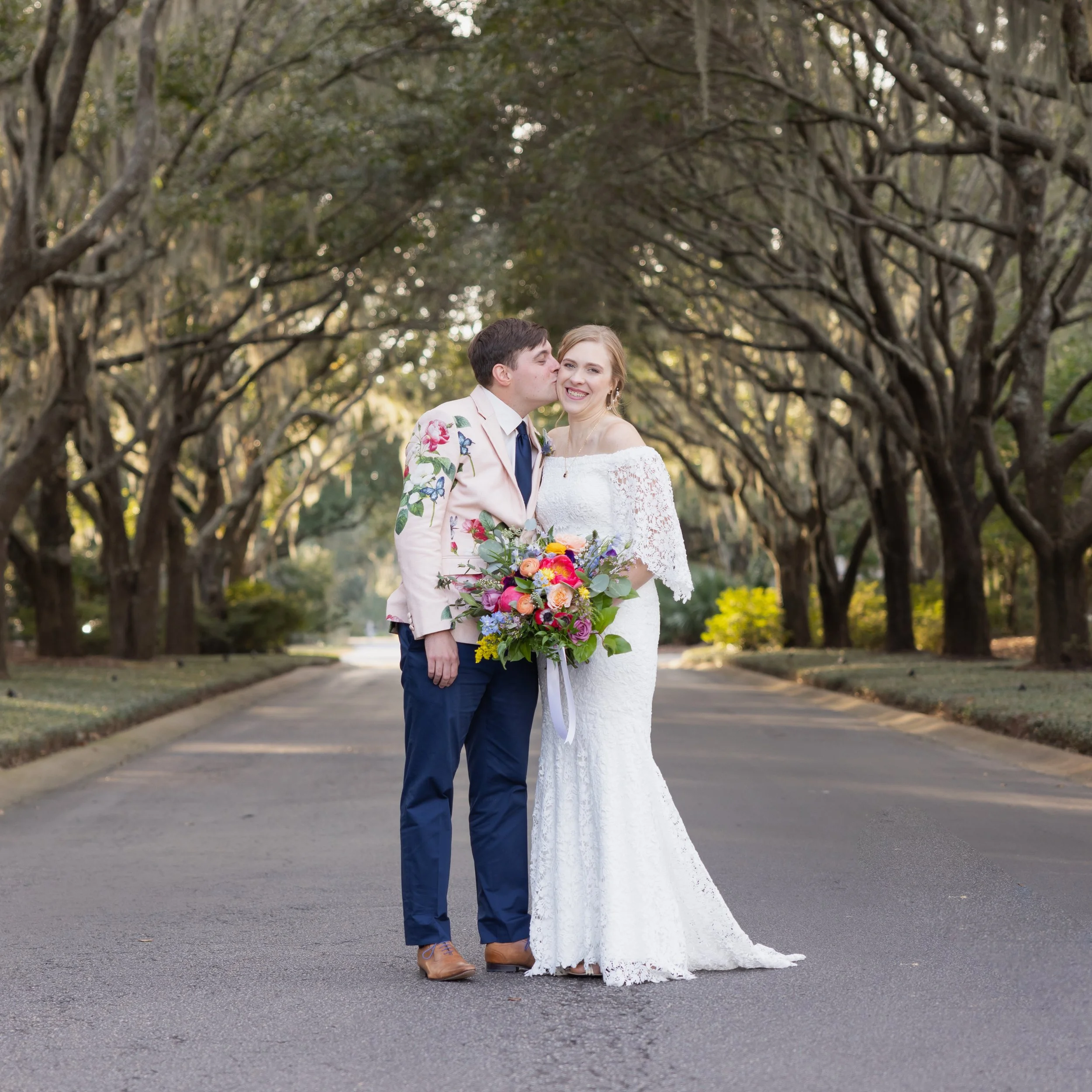 groom kissing bride at Debordieu CLubhouse under oaks