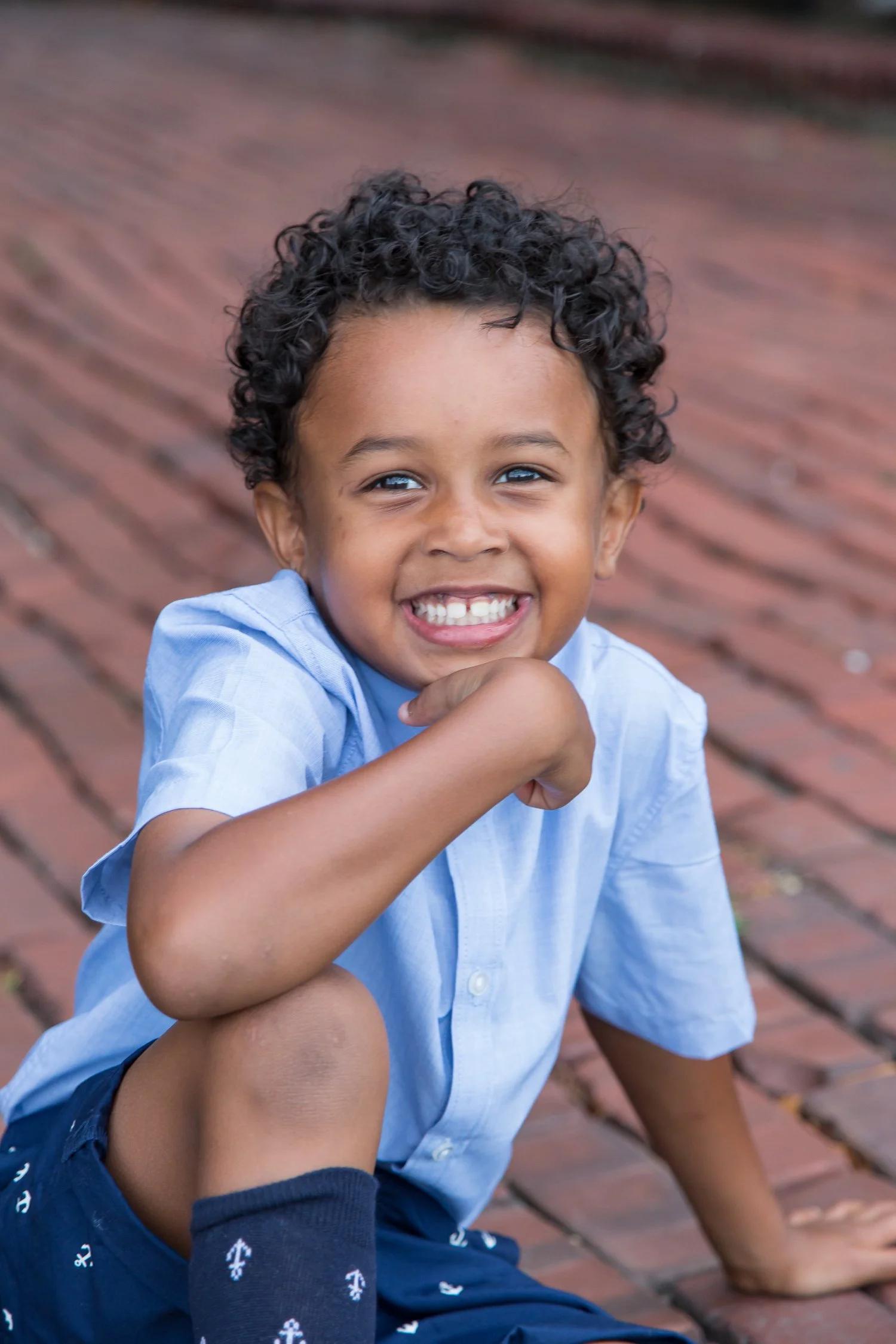 playful young boy portrait on red brick road