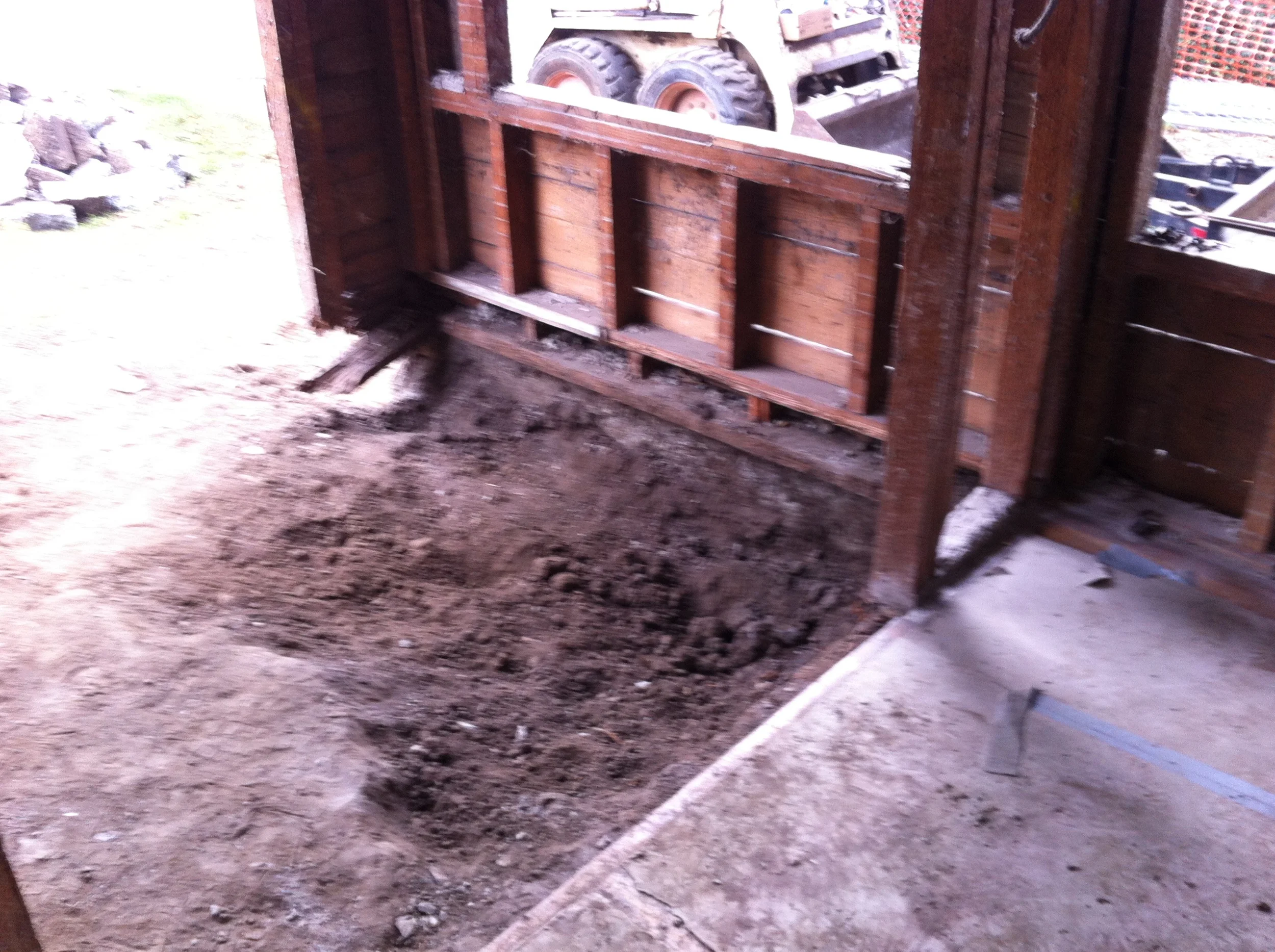 This is why there were termites. The old entry was an even older(?) porch with a concrete floor. The dirt underneath was up against the floor framing.