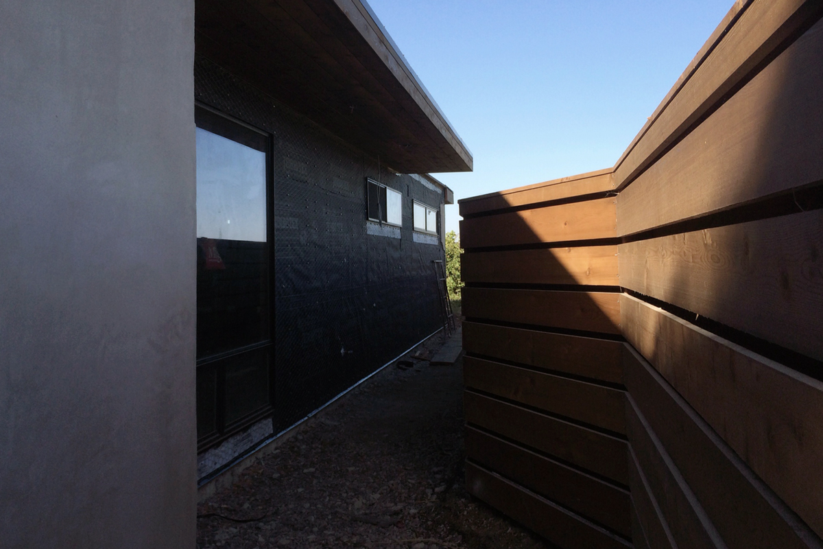new cedar fence + awning / smooth stucco + lath / metal windows