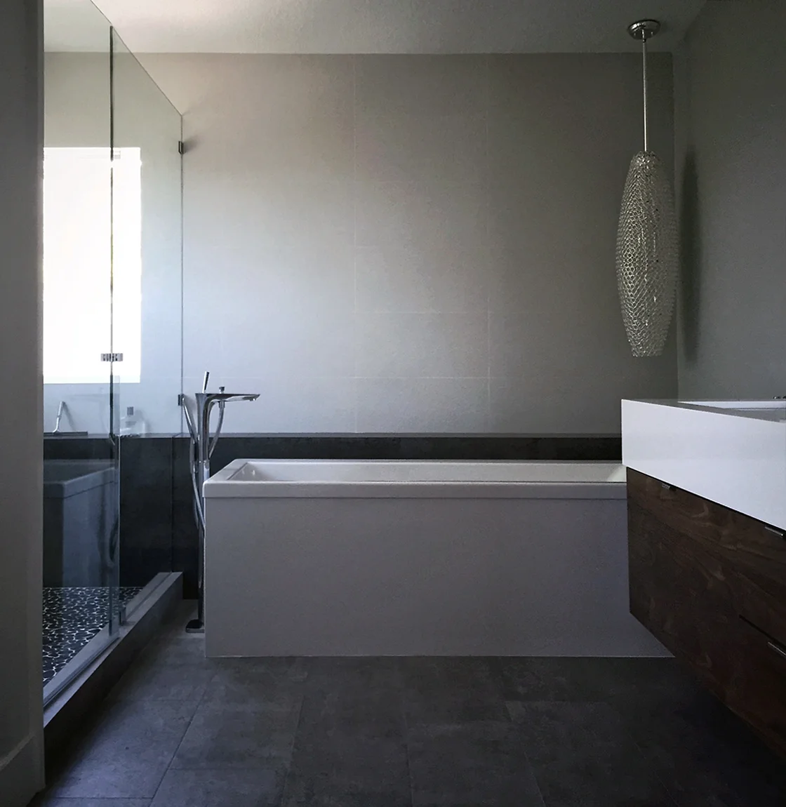 freestanding bath at cantilevered walnut vanity