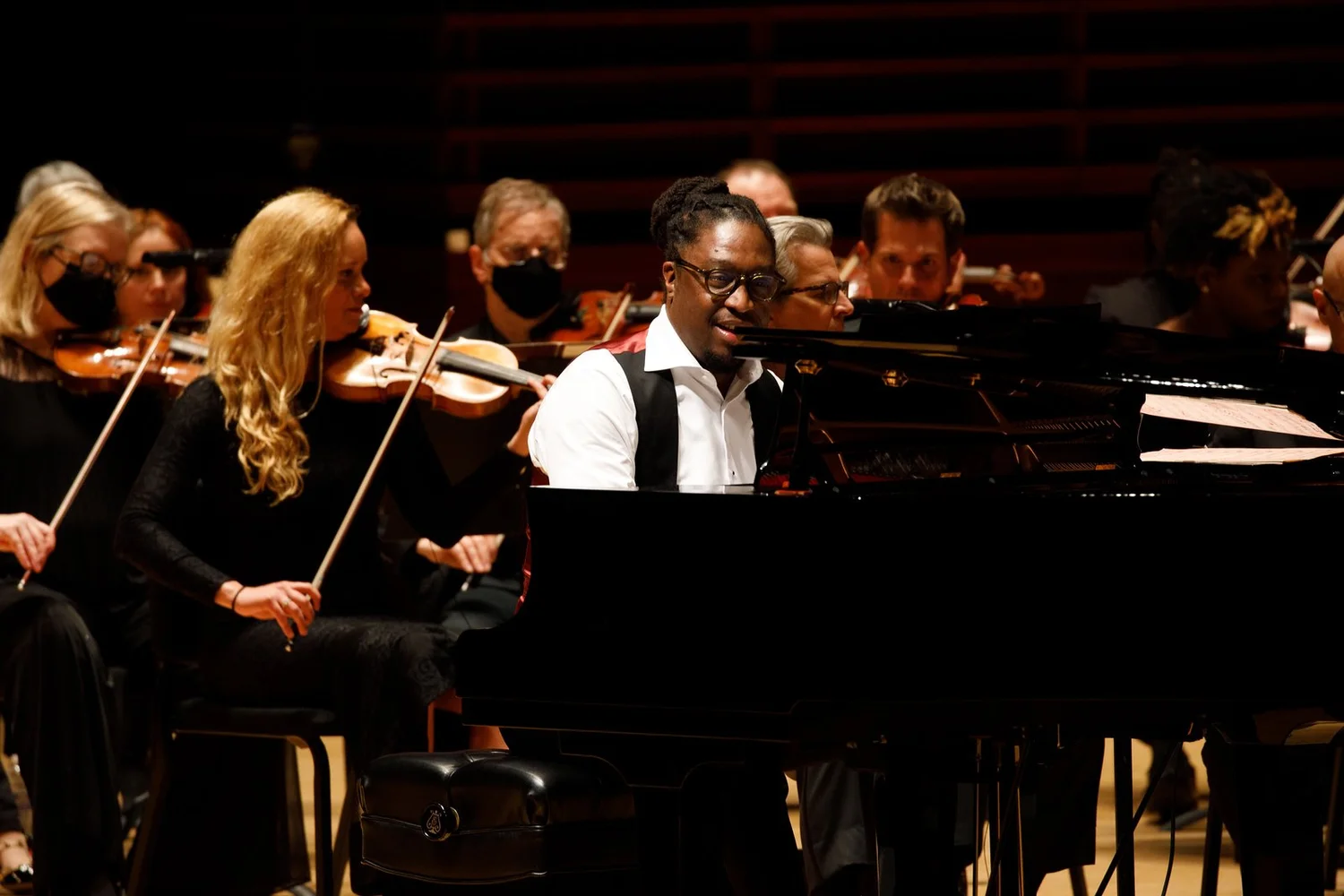 George Burton at the piano in front of a string orchestra