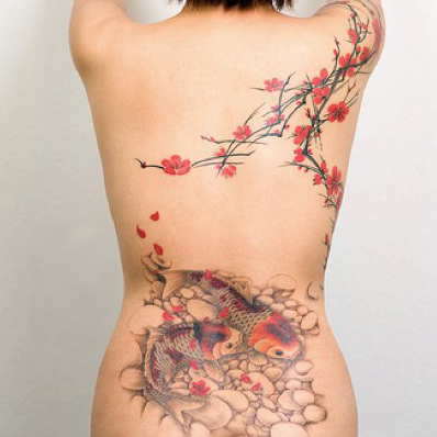 Tattoo of koi in a pond beneith a flowering tree