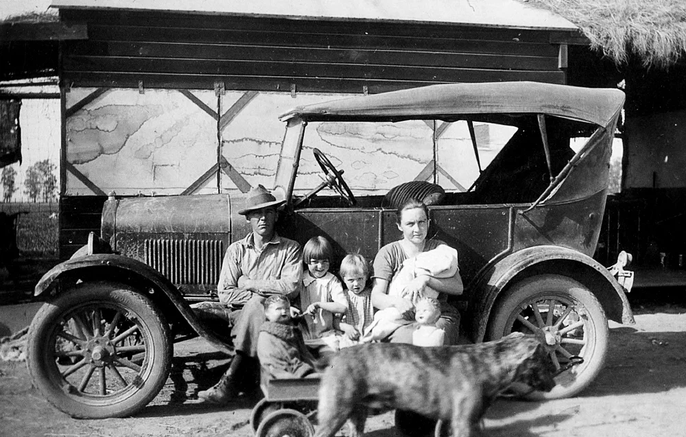 A family beside an old truck in the Saarloos + Sons photo archive