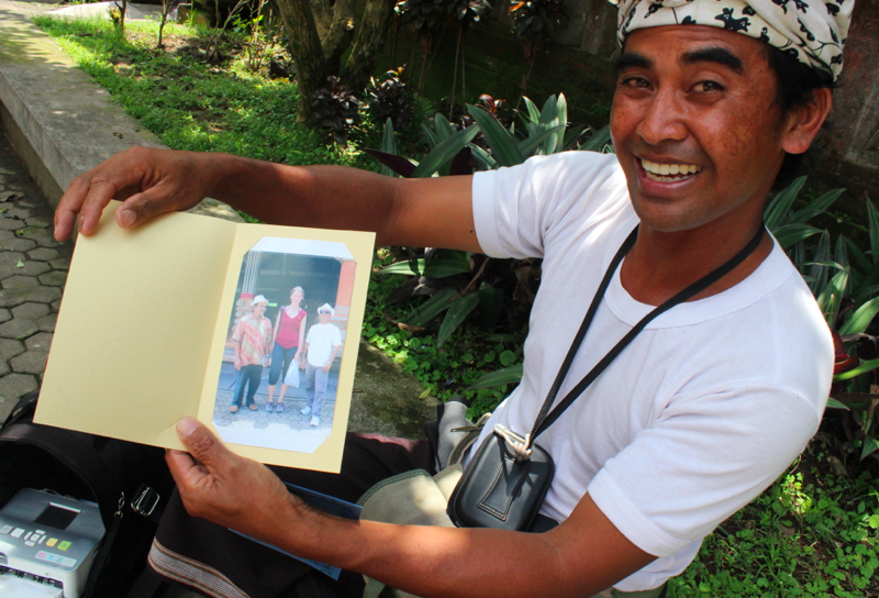 Balinese guy selling photo of familiar very tall white girl with short Javanese tourists to said Javanese tourists