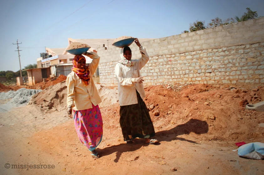 More female construction workers carrying bowls of gravel on their head (Photo by: C. Paine)