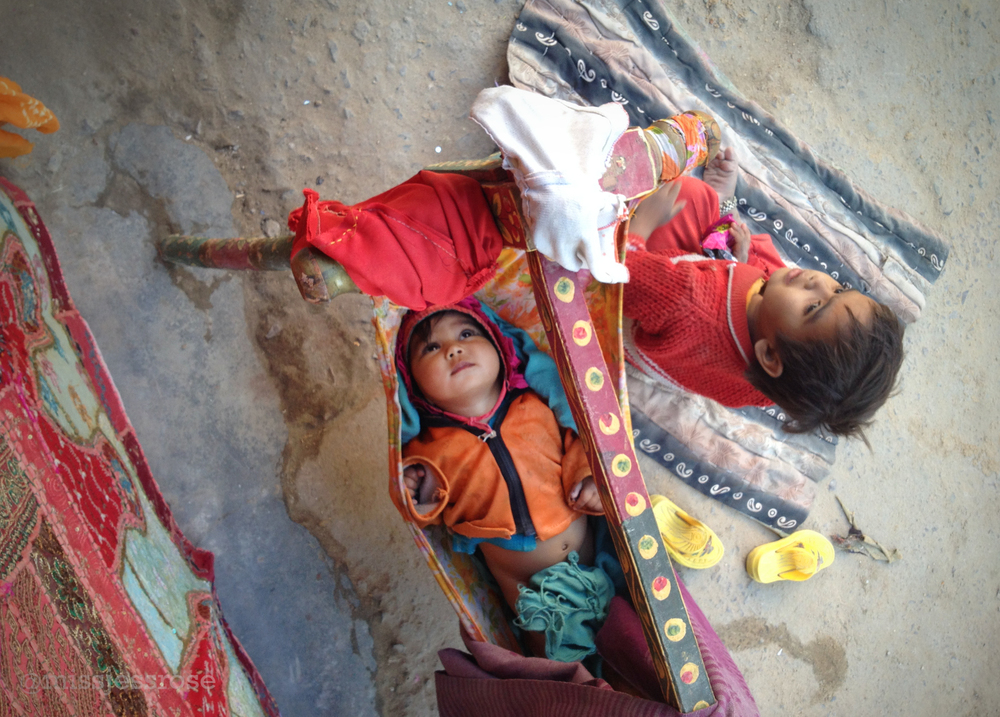 Babies wait while mom hauls cement.