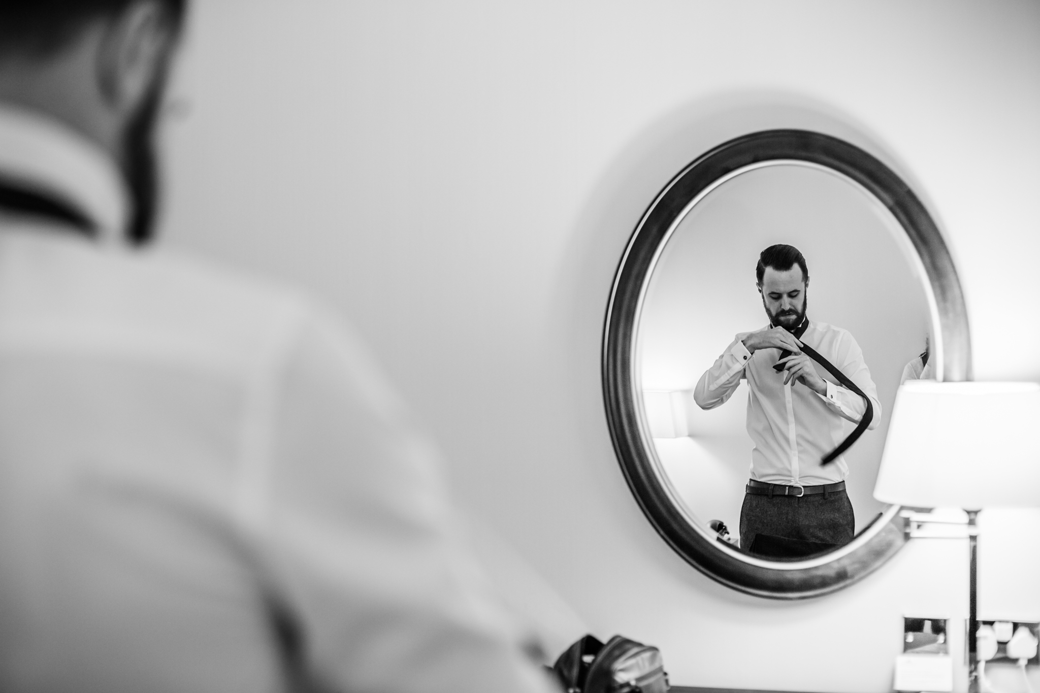 reflection of a groom getting ready