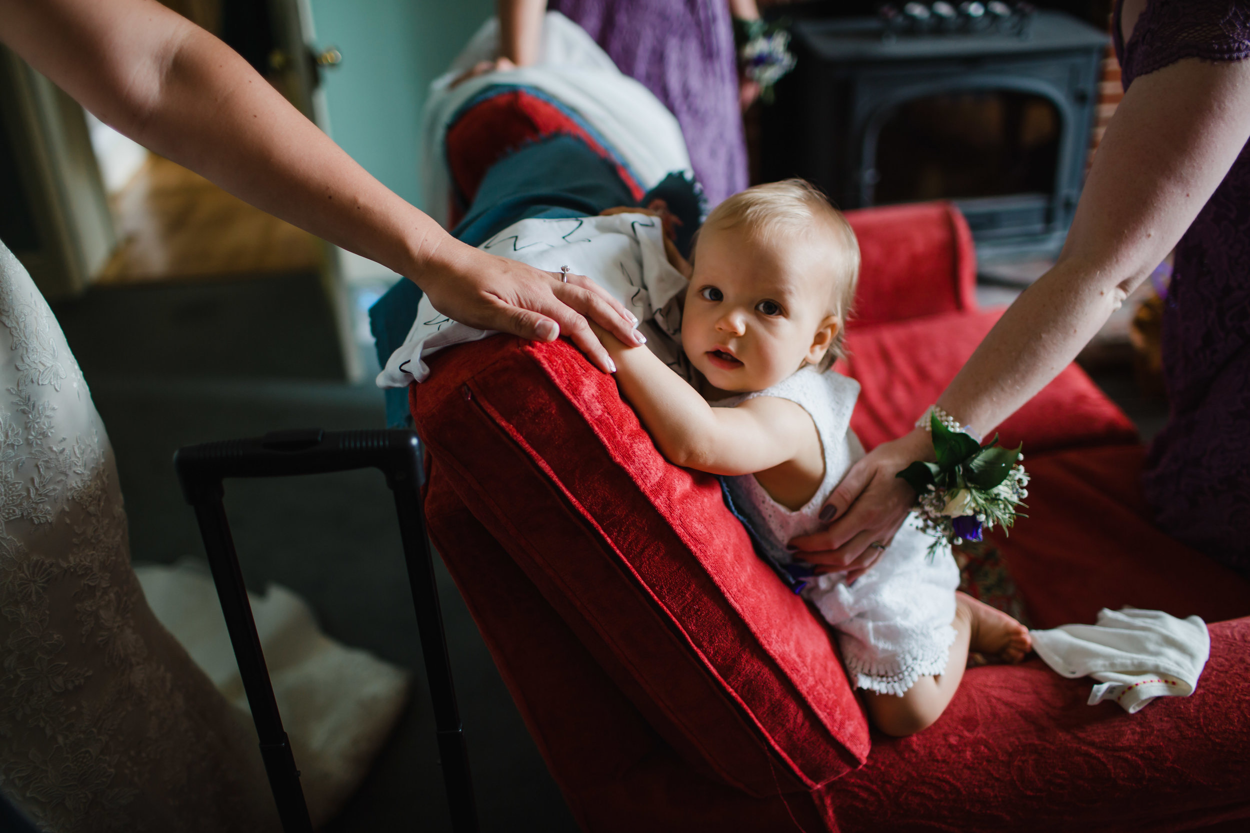 A bride holds the hand of her baby daughter as she dresses for her wedding in Norfolk