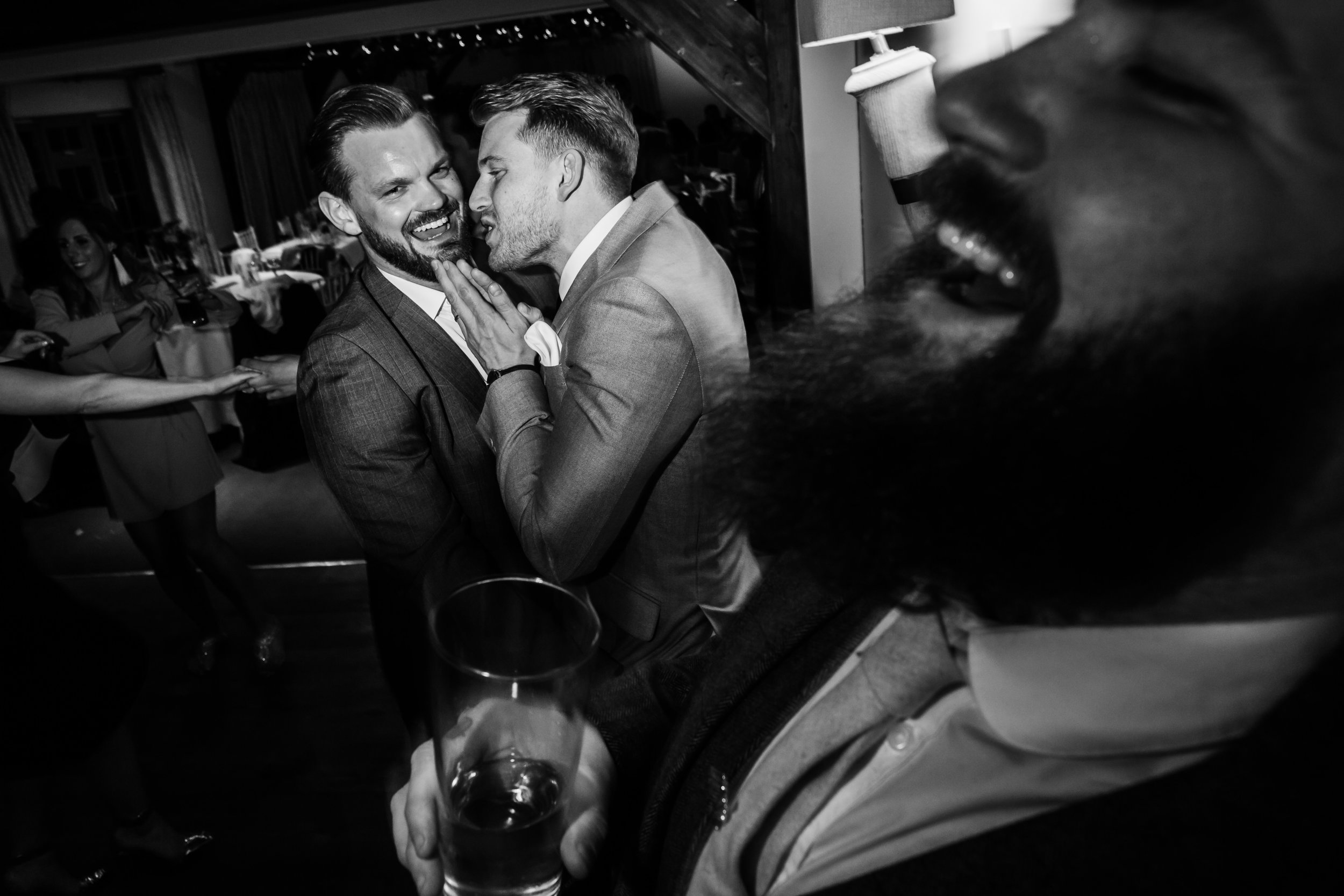 a groom laughs while his friends joke around at the compasses at pattiswick